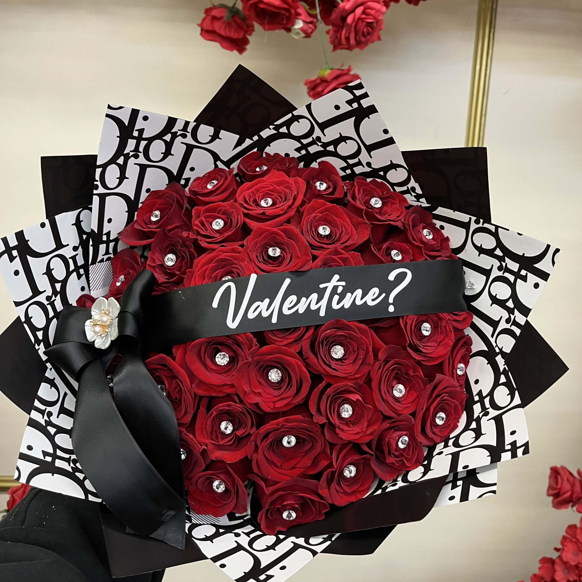 Bouquet of red roses wrapped in black-and-white paper with a black ribbon