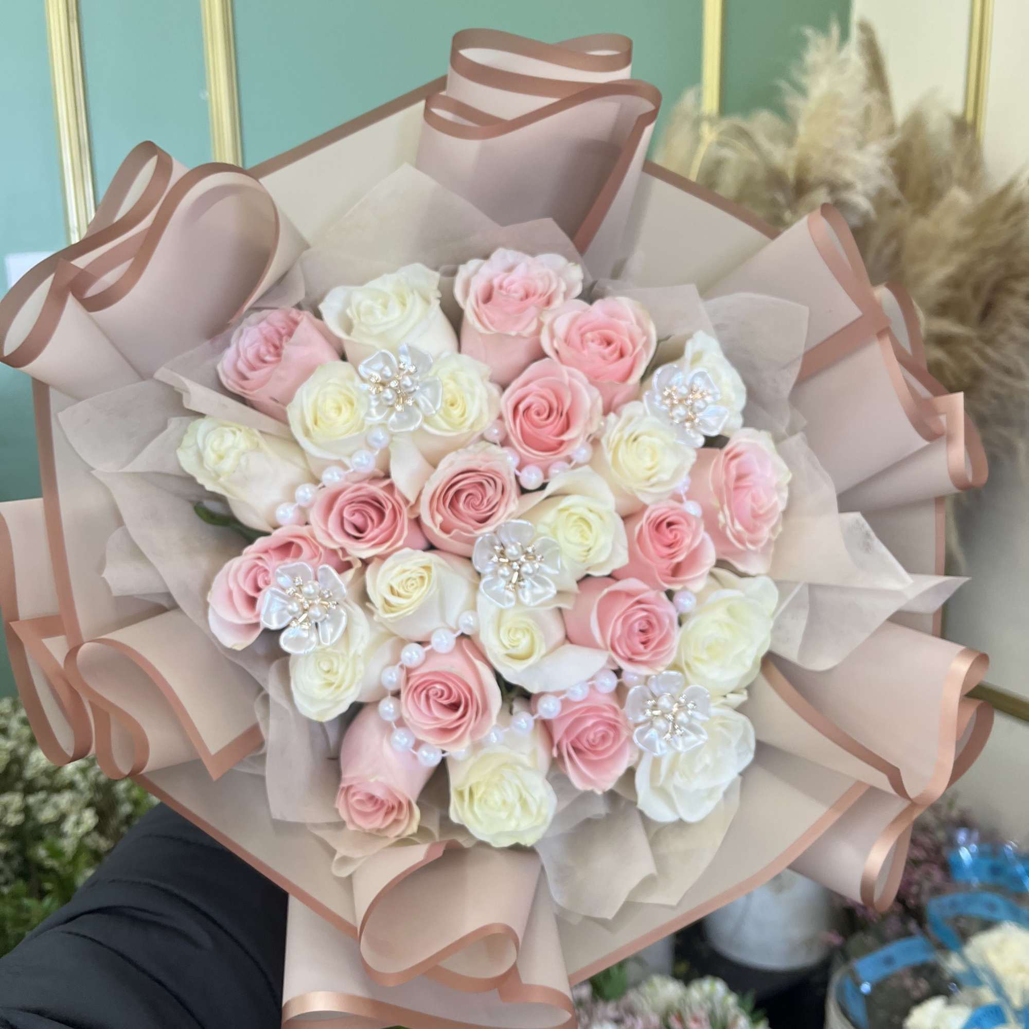 Bouquet of pink and white roses wrapped in blush paper