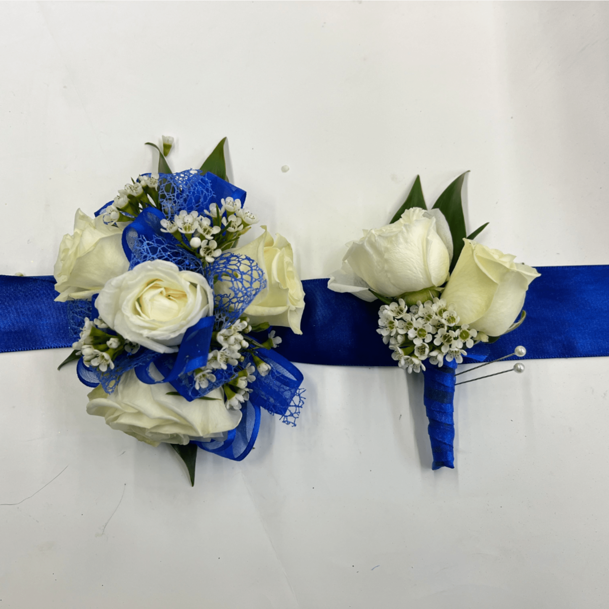 White rose corsage and boutonniere set accented with baby&rsquo;s breath for a, photo 2 of 4