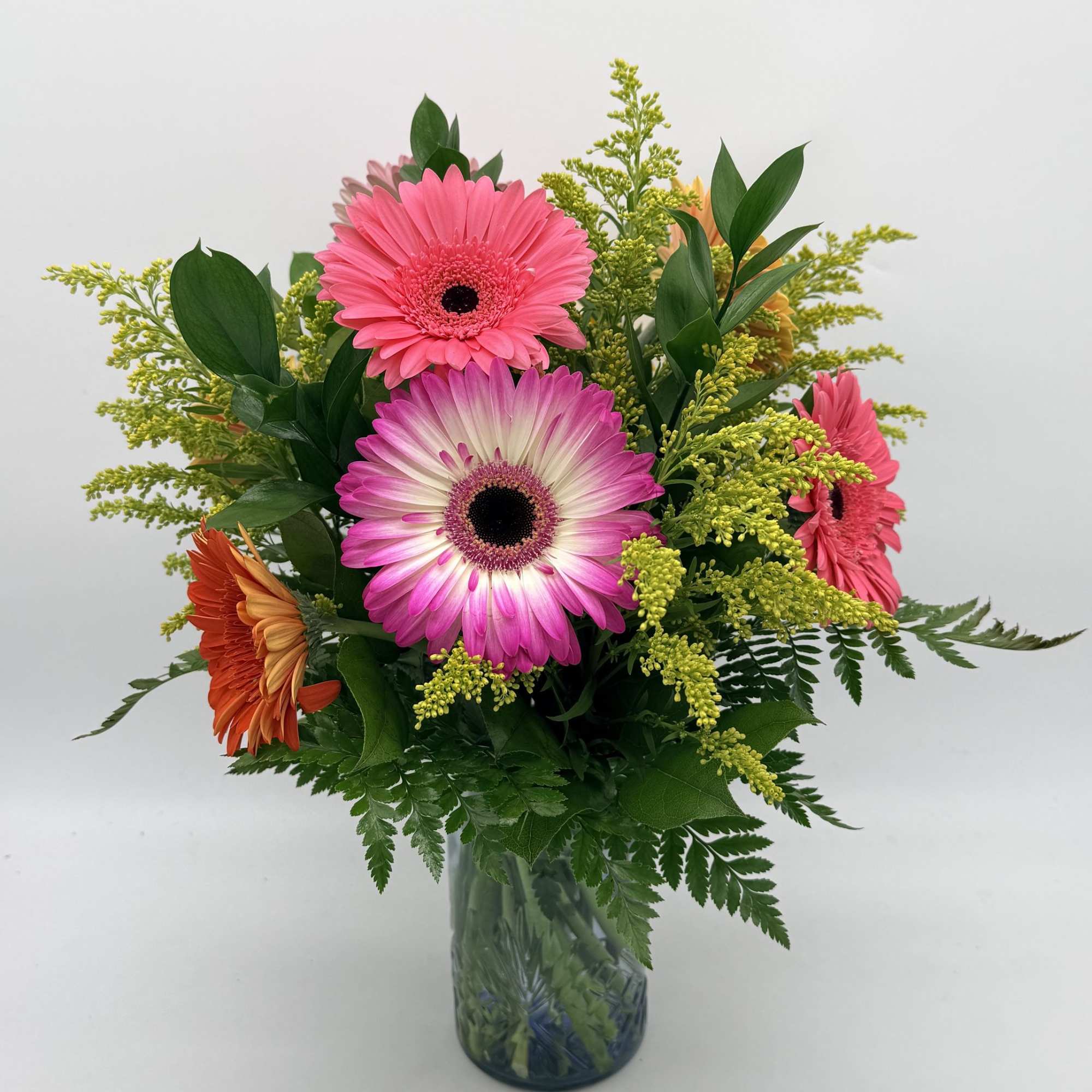 A joyful bouquet featuring vibrant gerbera daisies accented with snapdragons and greenery.