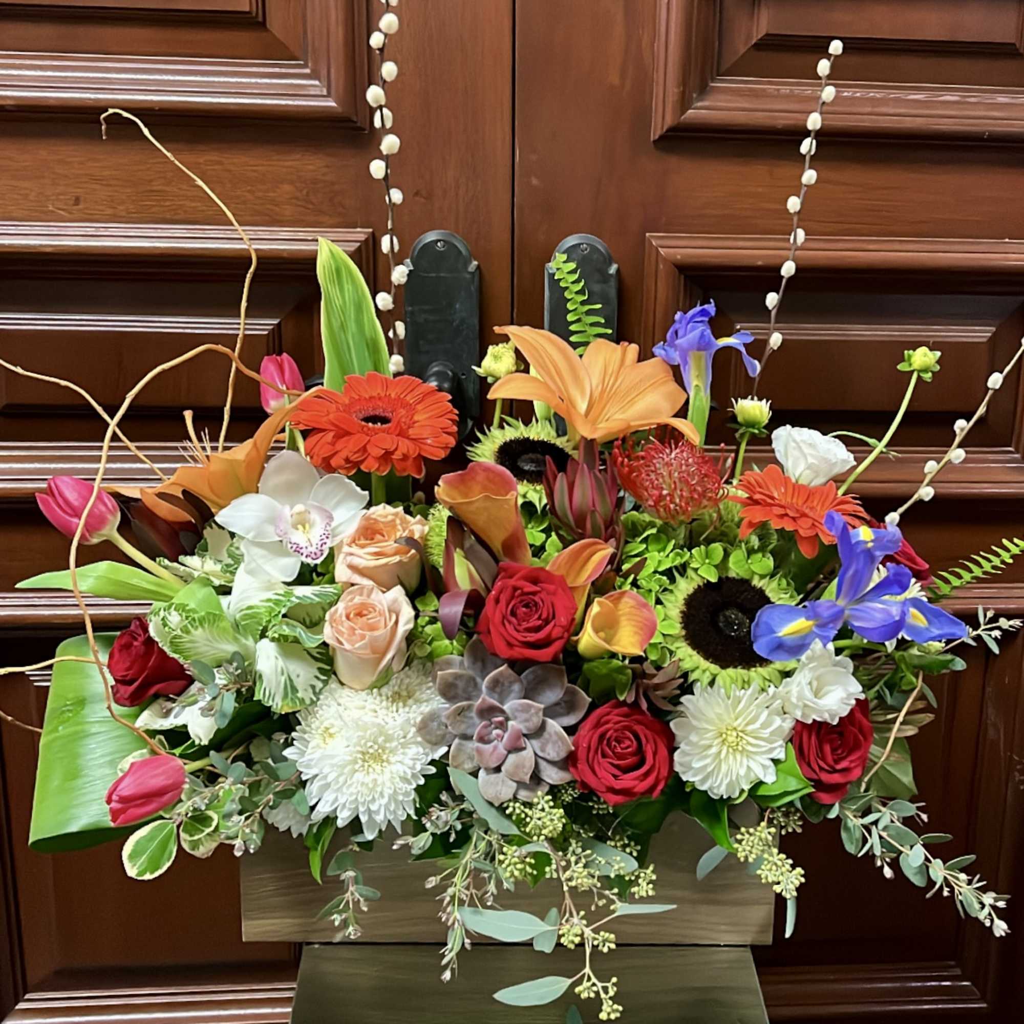 Colorful mixed flower arrangement in a rectangular wooden container