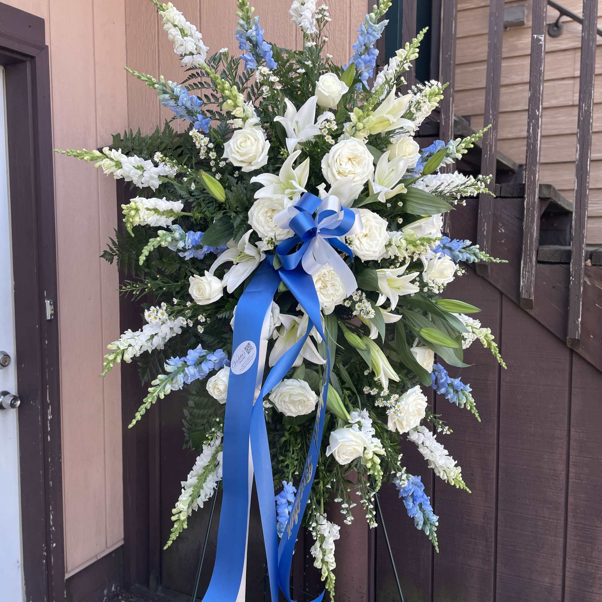 A serene, formal standing spray that reads as a respectful tribute-crafted for