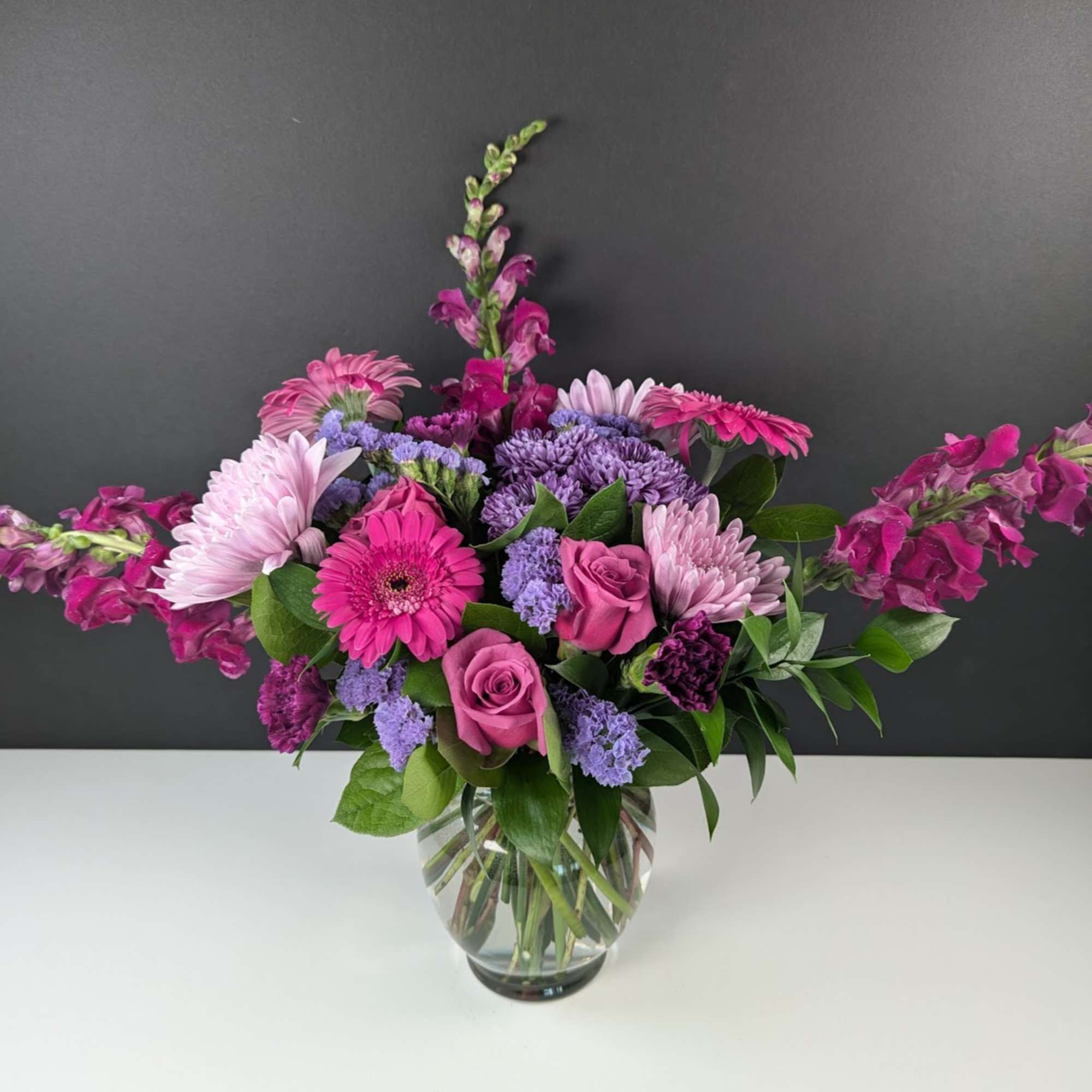 Pink and purple mixed bouquet in a clear glass vase