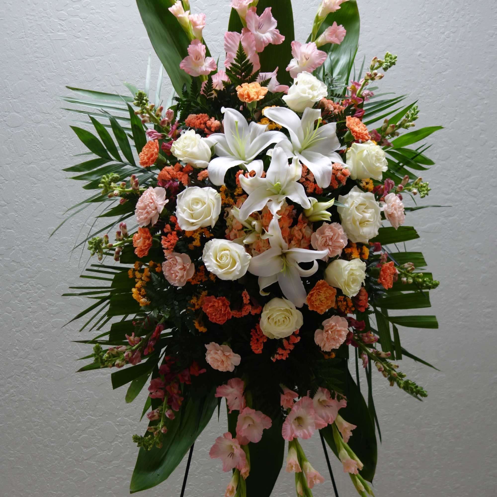 Standing floral spray with white lilies, roses, and pink blooms