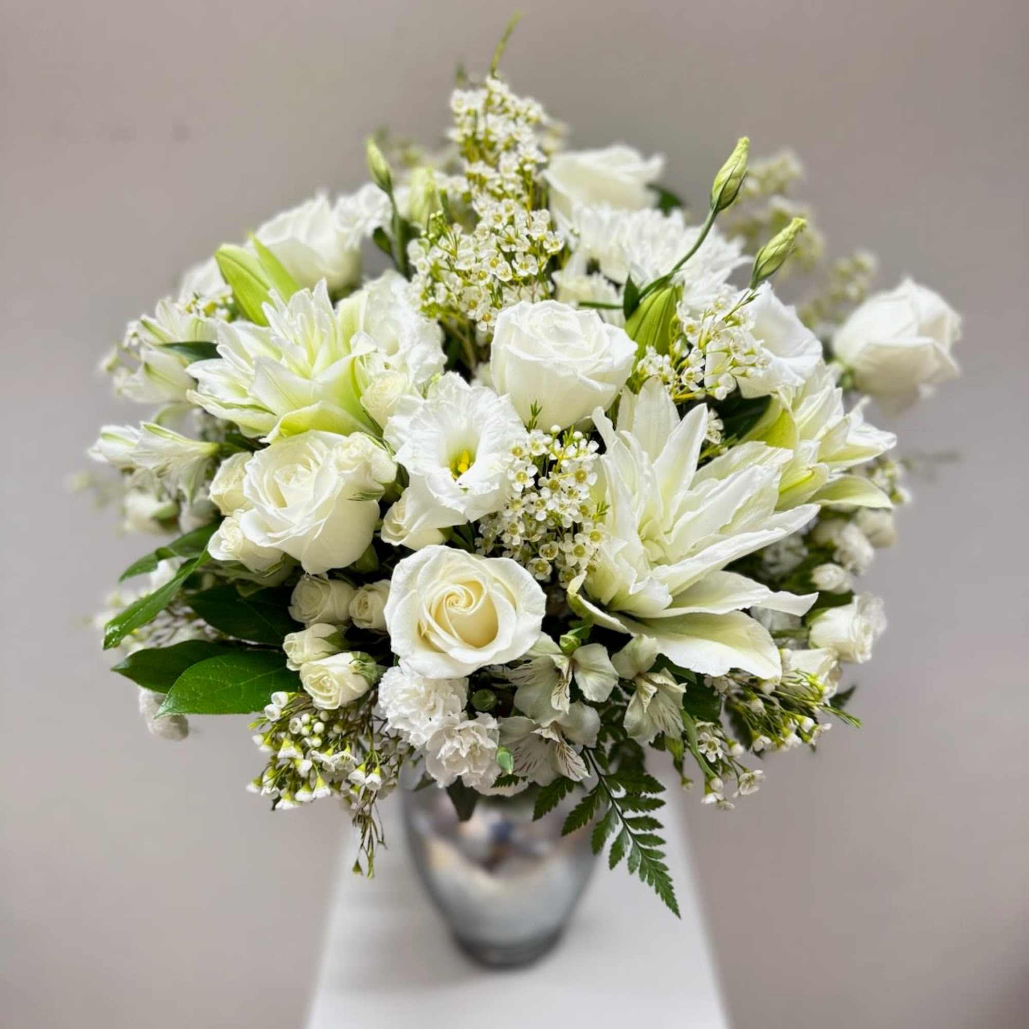 White rose and lily bouquet in a silver vase