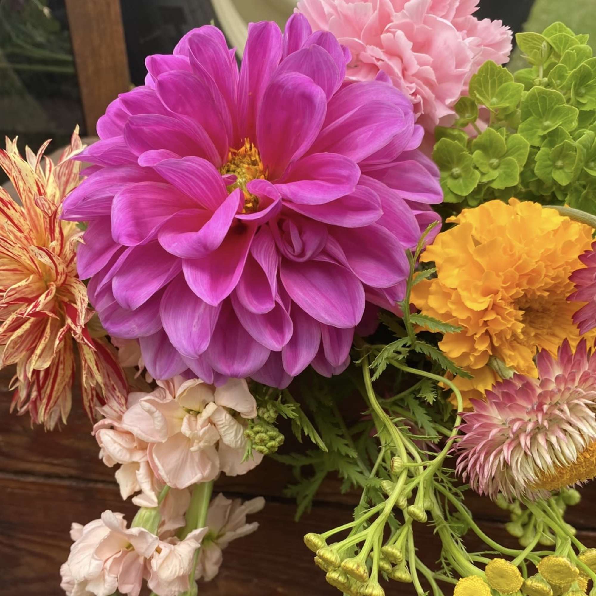 Bright mixed bouquet with a large magenta dahlia and pink, yellow, and green blooms