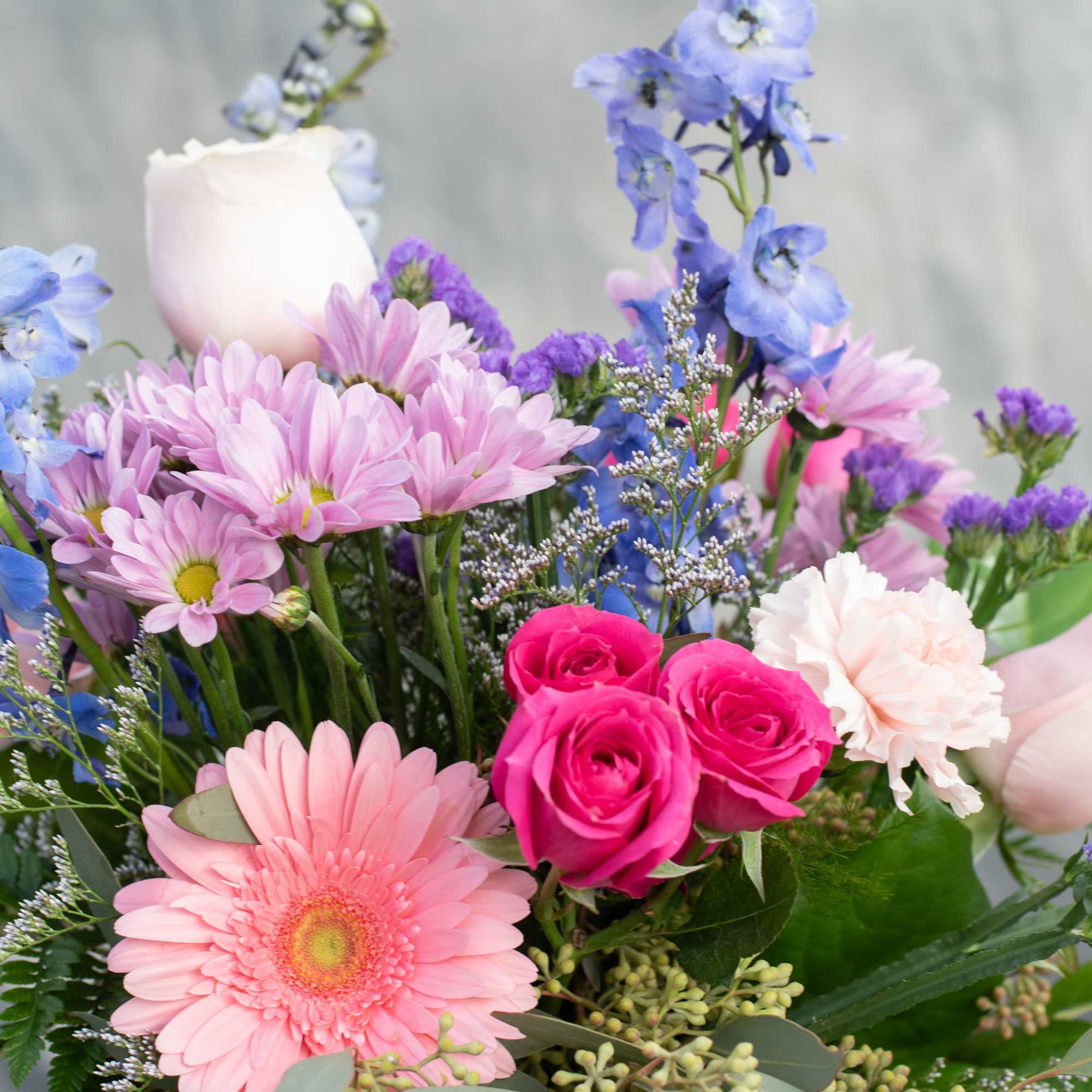 Pink and blue mixed bouquet with roses, daisies, and carnations