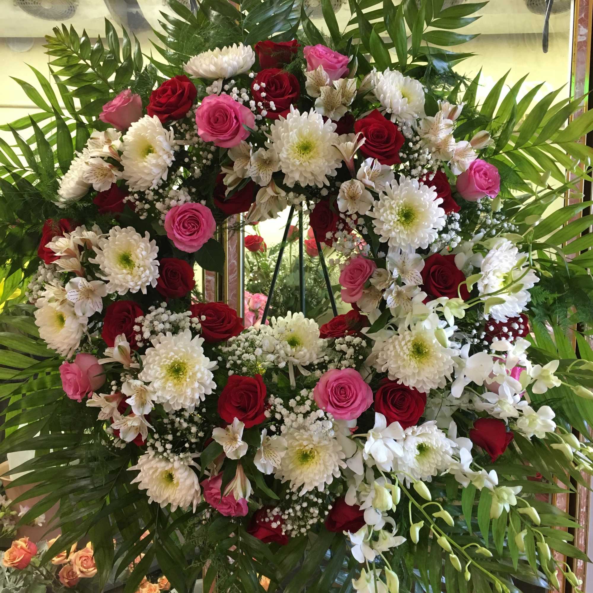 Large floral wreath with red and pink roses and white chrysanthemums