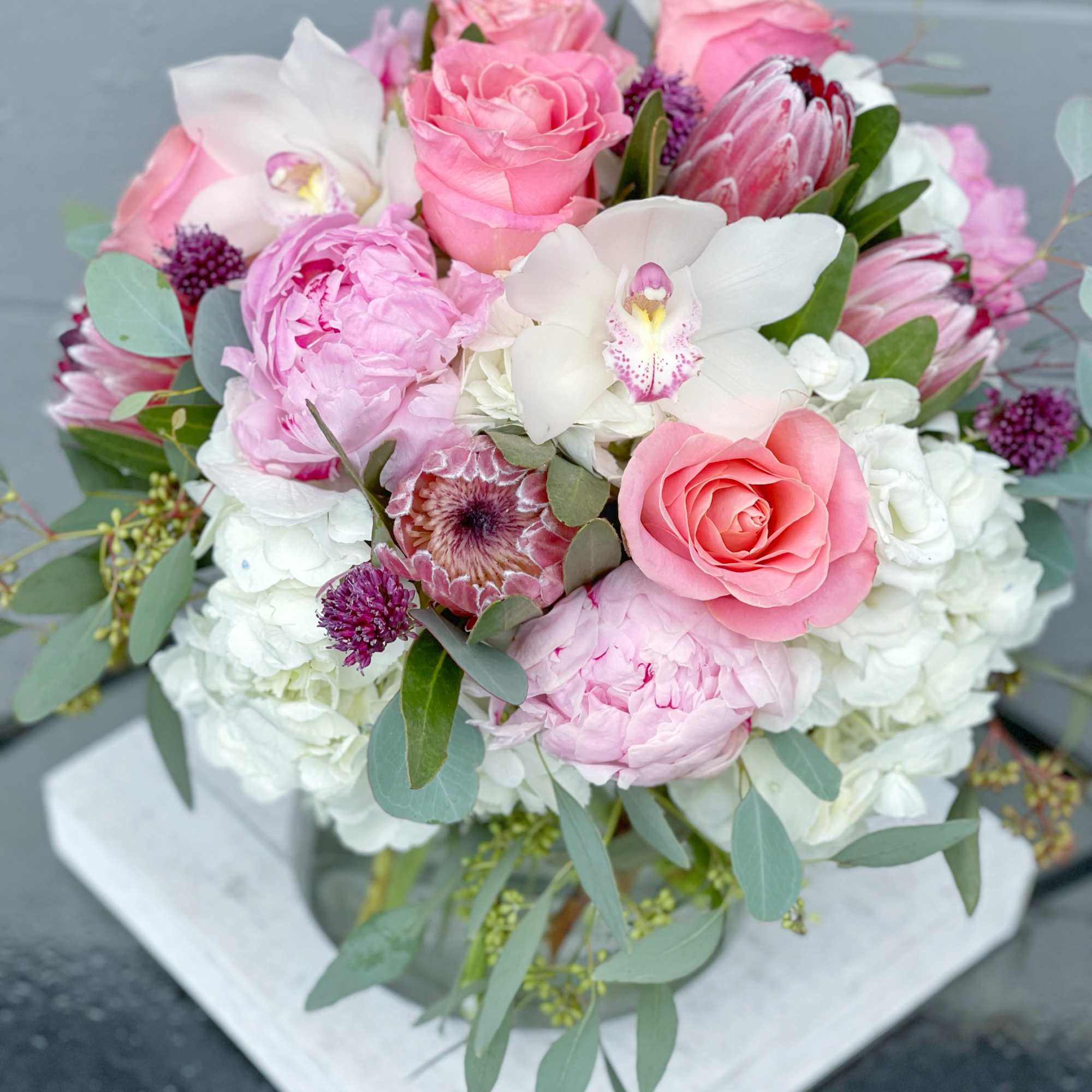 Pink and white bouquet with roses, orchids, and peonies