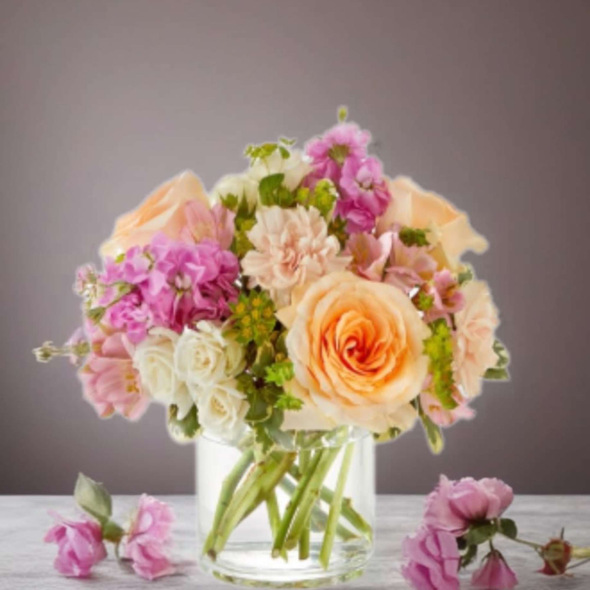 Peach and pink flower bouquet in a clear glass vase