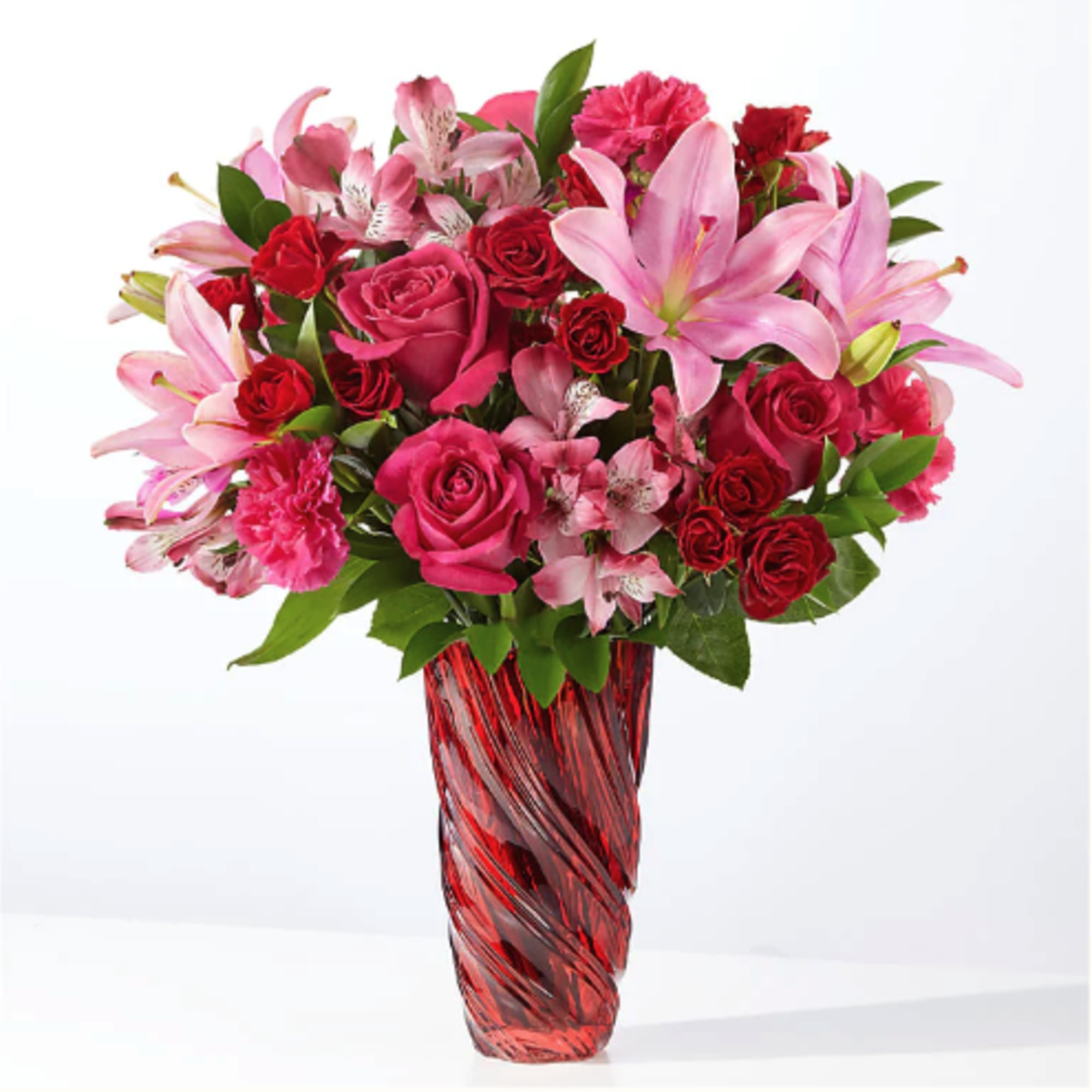 Pink and red mixed bouquet in a red glass vase