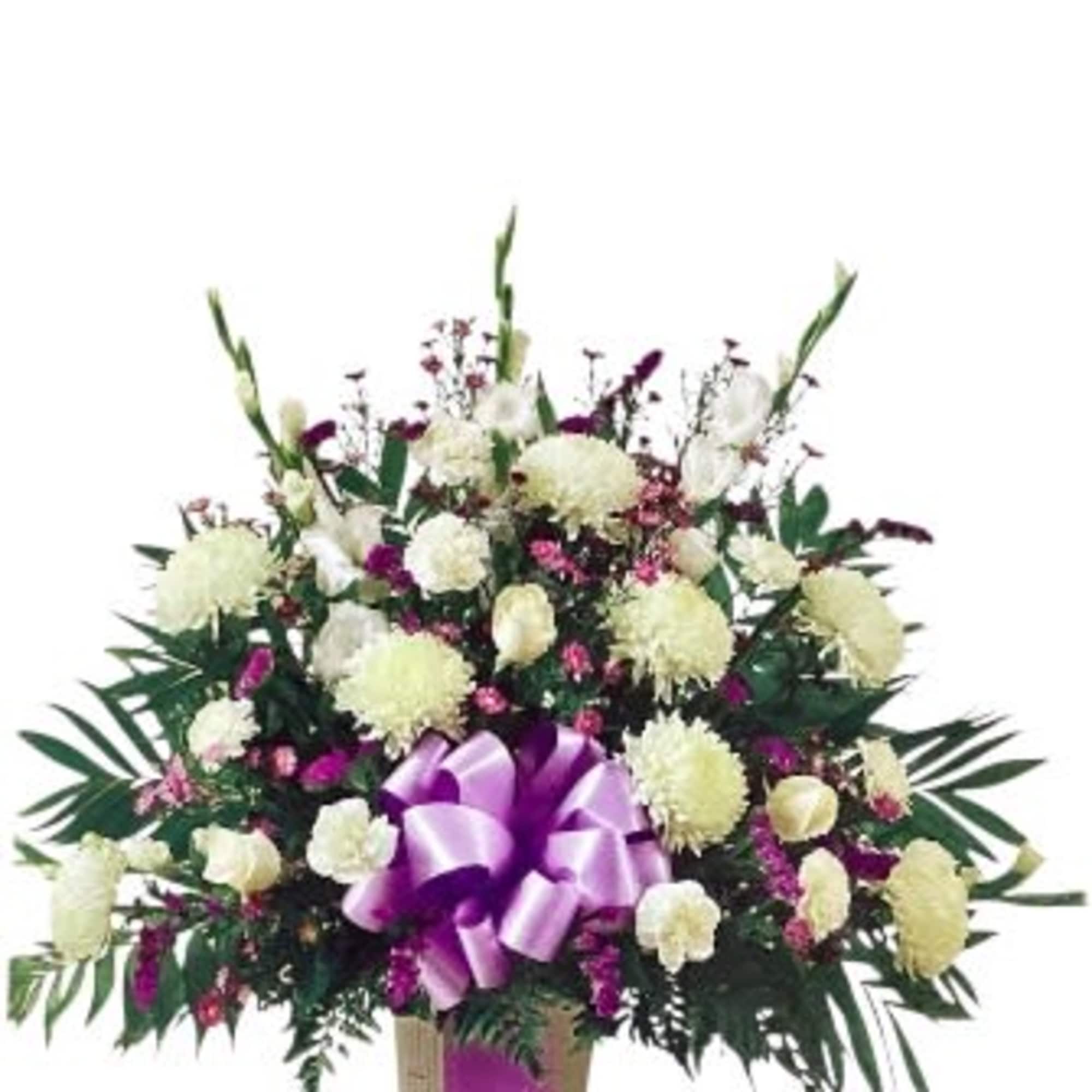 White and purple floral spray with a lavender ribbon on a stand
