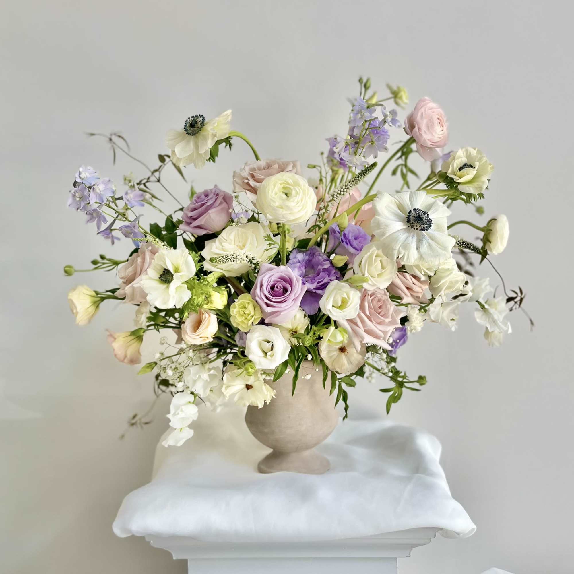 Front side arrangement with a deluxe size pedestal vase. Decorated with pastel