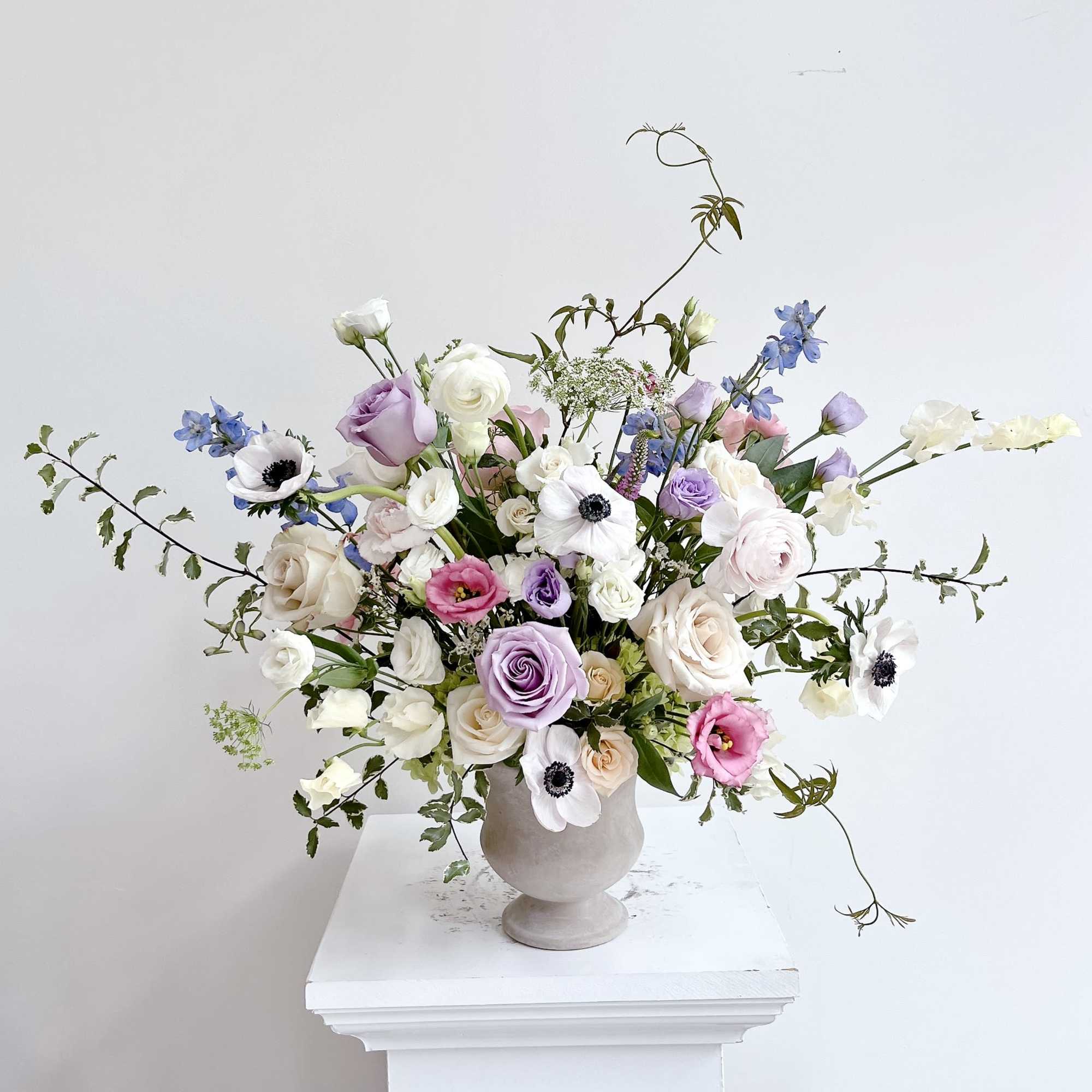 Front side arrangement with a deluxe size pedestal vase. Decorated with pastel
