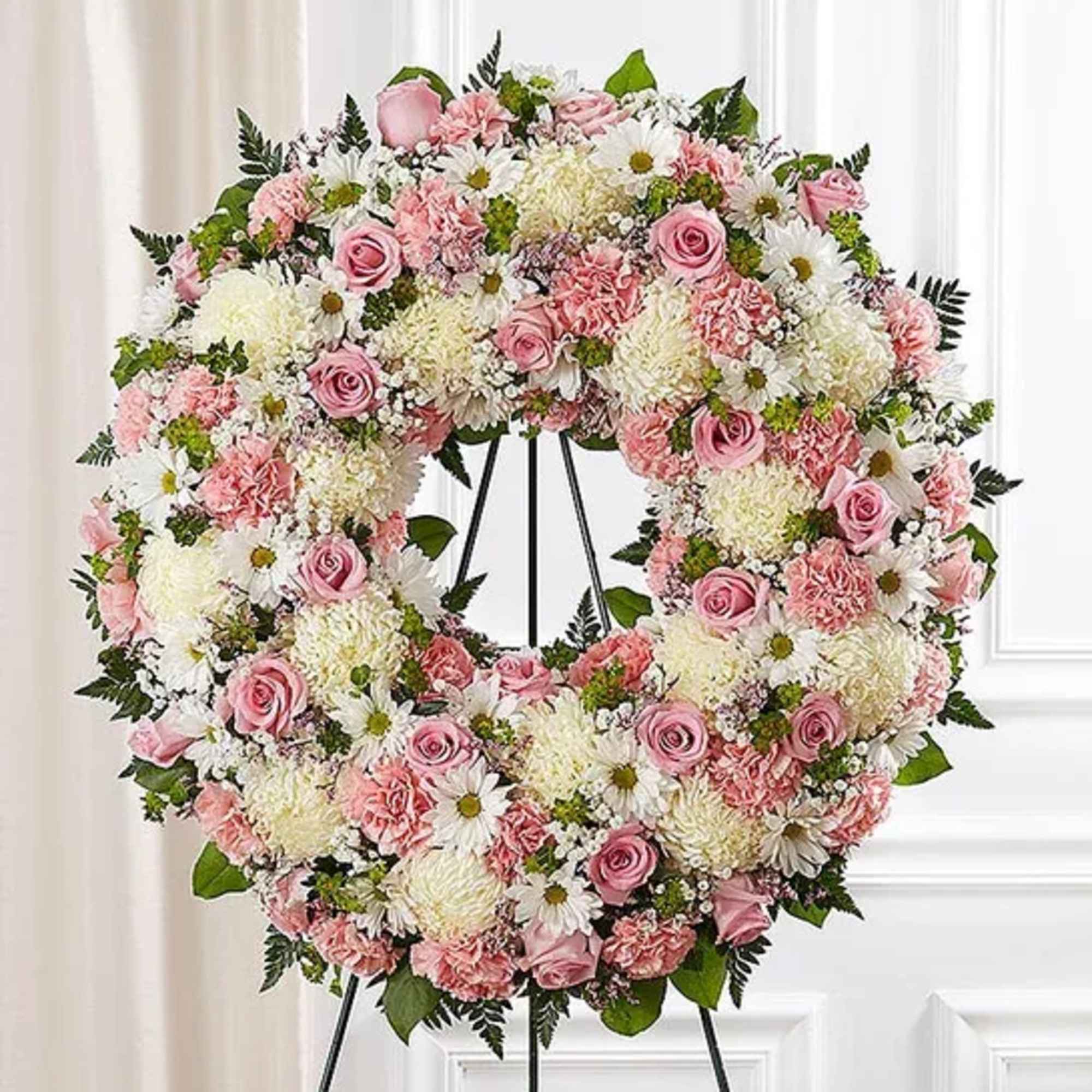 Standing wreath arrangement with pink roses, carnations and limonium; white football mums