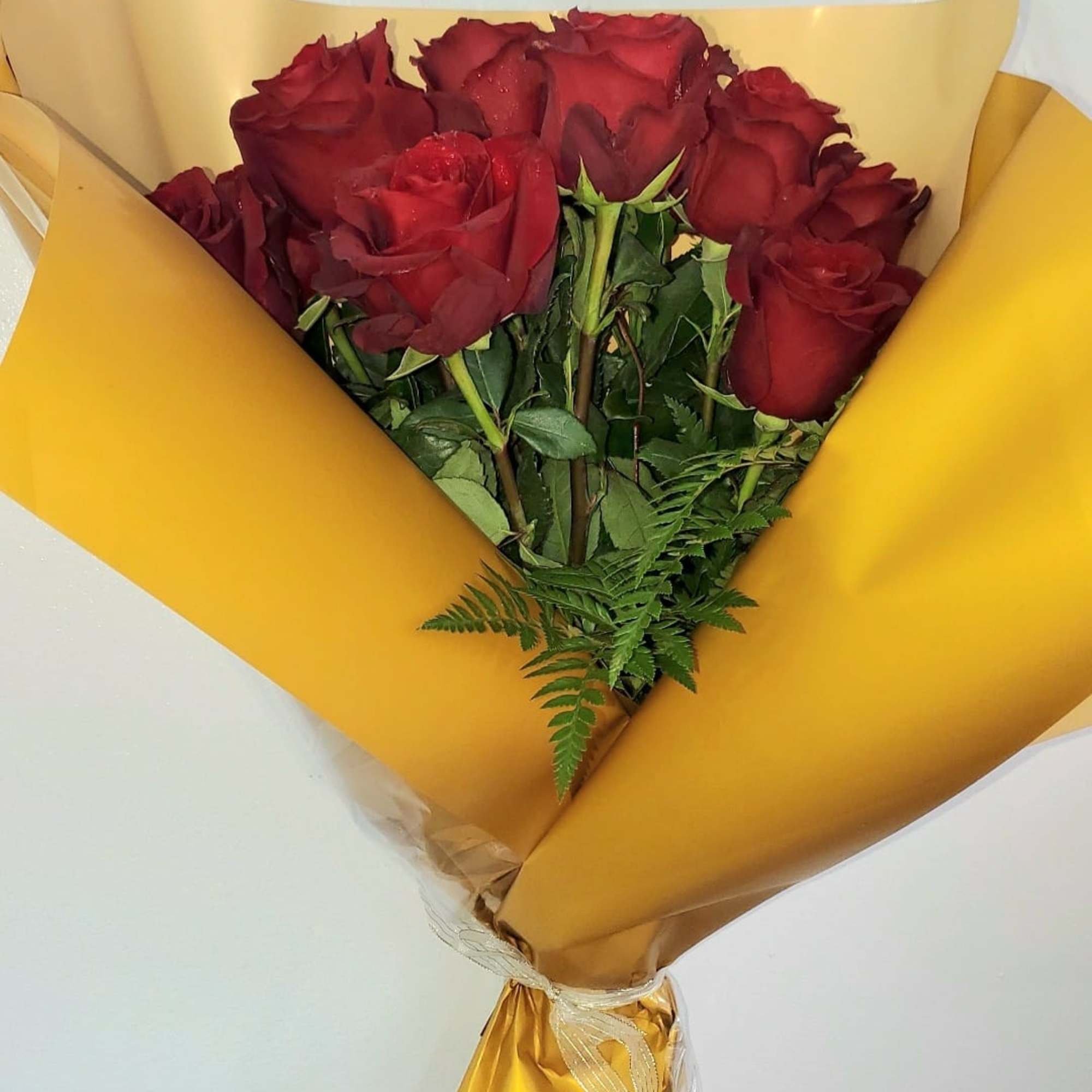 Bouquet of red roses wrapped in yellow paper