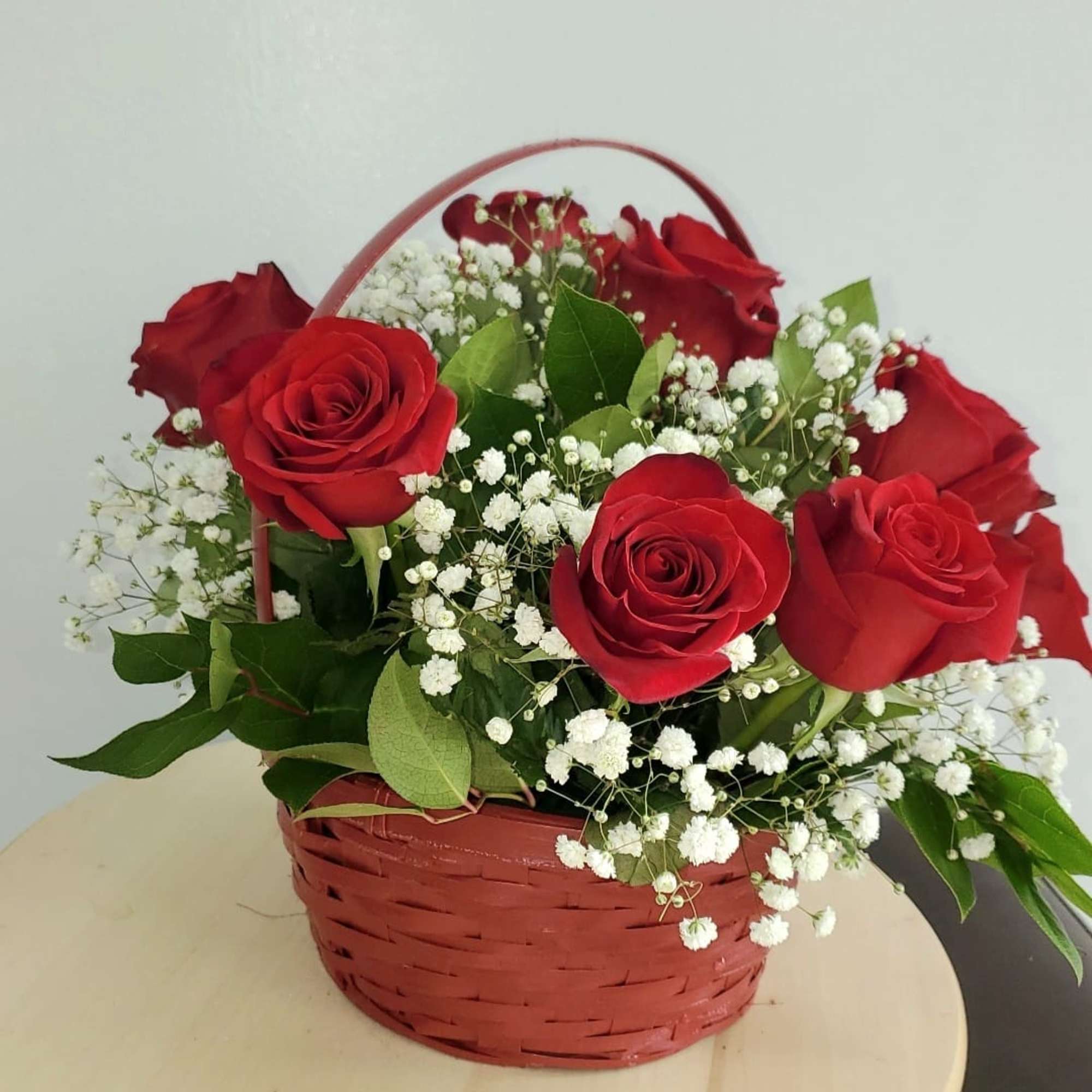 Red roses and white baby's breath in a red basket