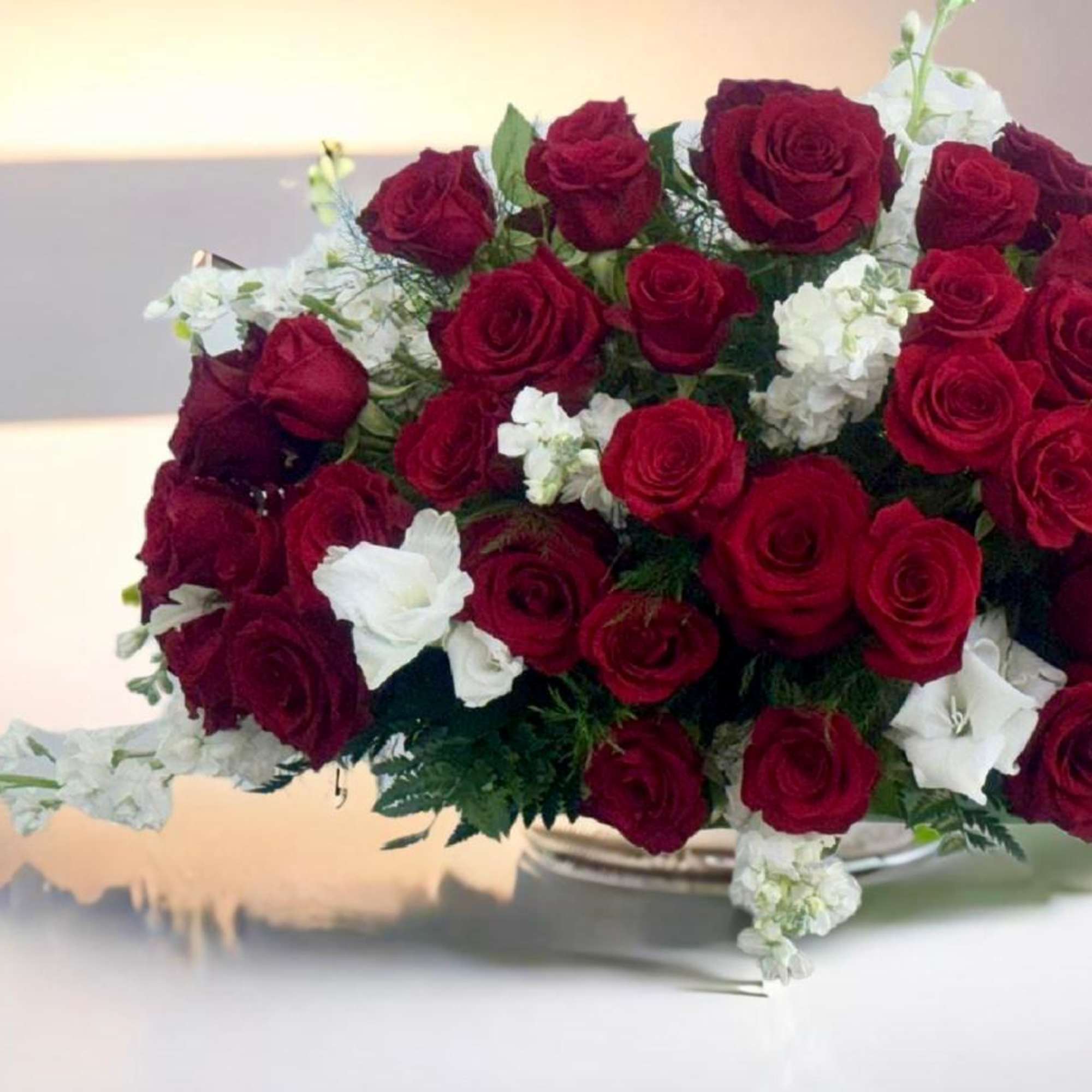 Large bouquet of red roses and white flowers in a low vase