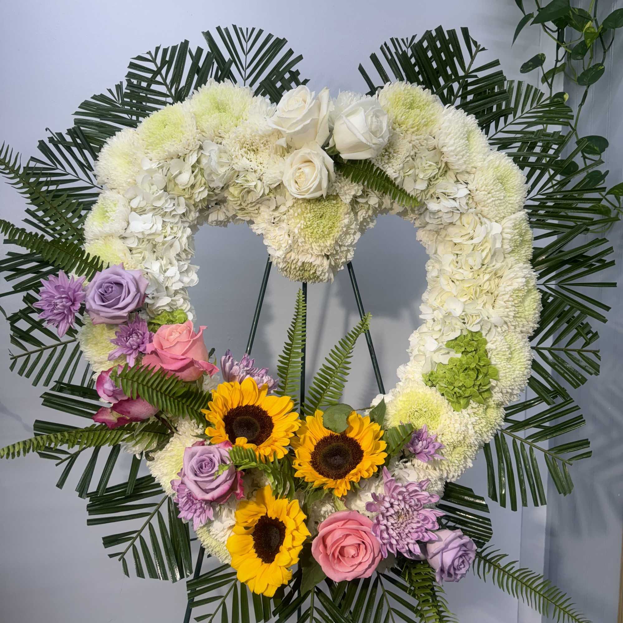 Heart-shaped floral wreath with white, pink, purple, and yellow flowers