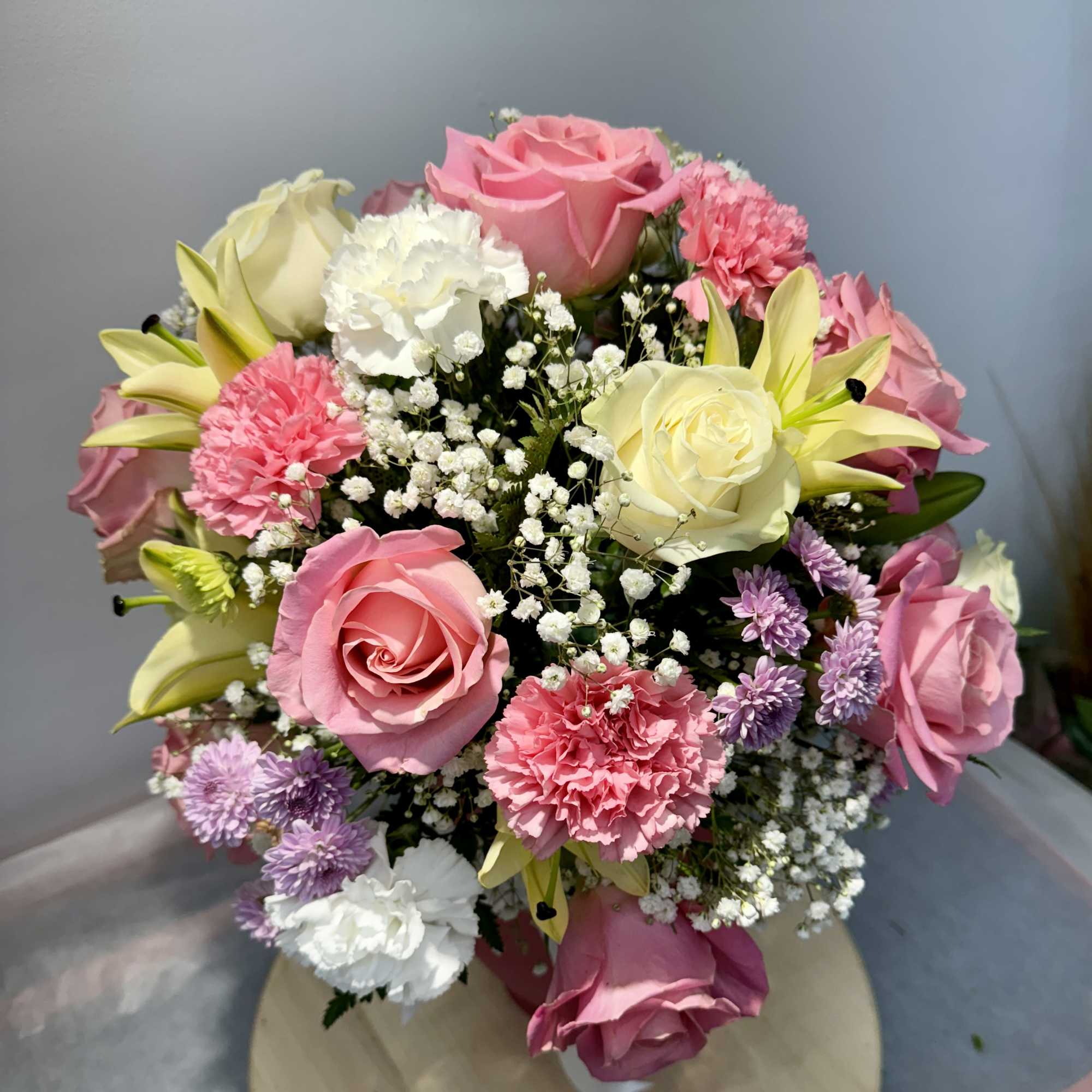 Bouquet of pink and white roses with lilies and carnations