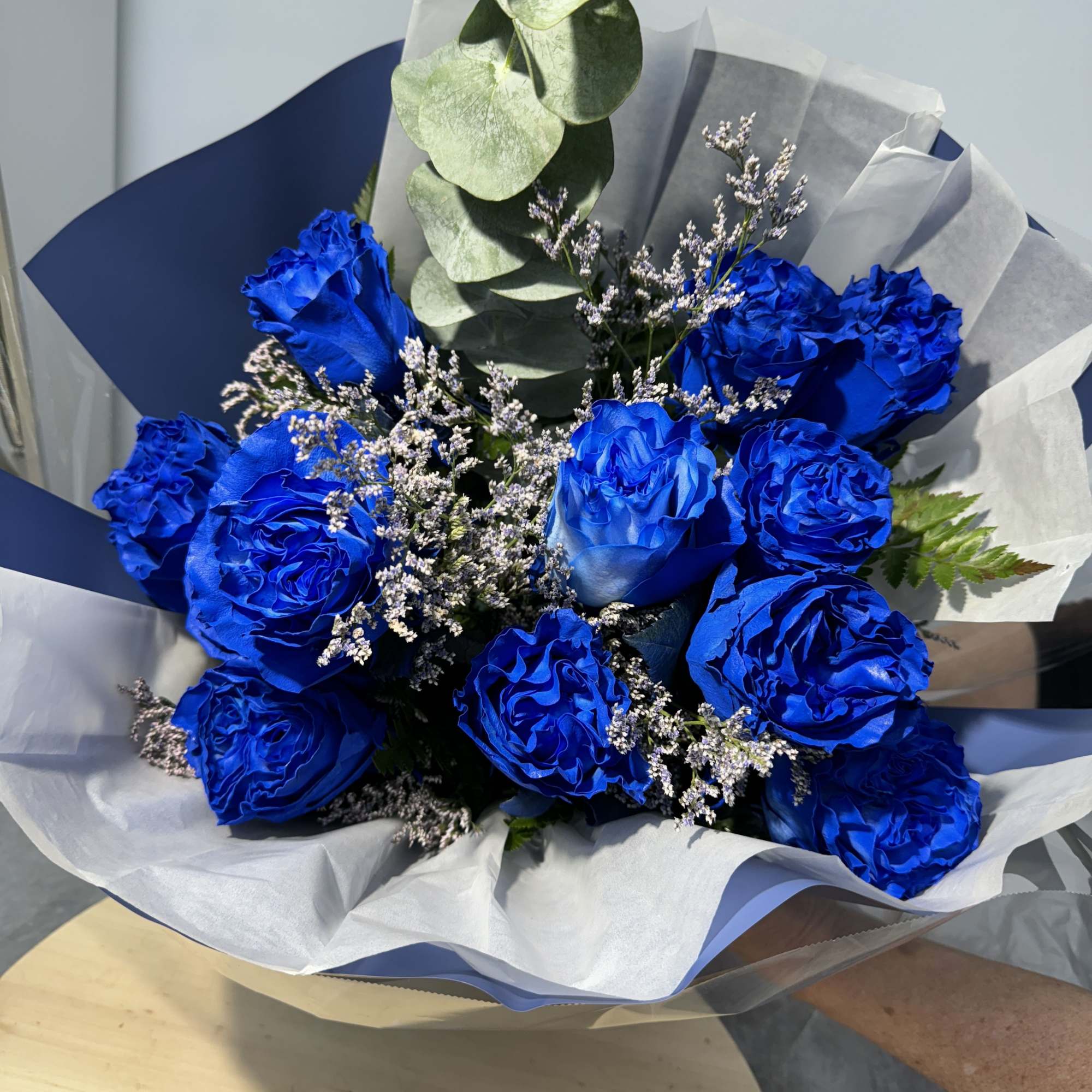 Bouquet of vivid blue roses with white filler and eucalyptus