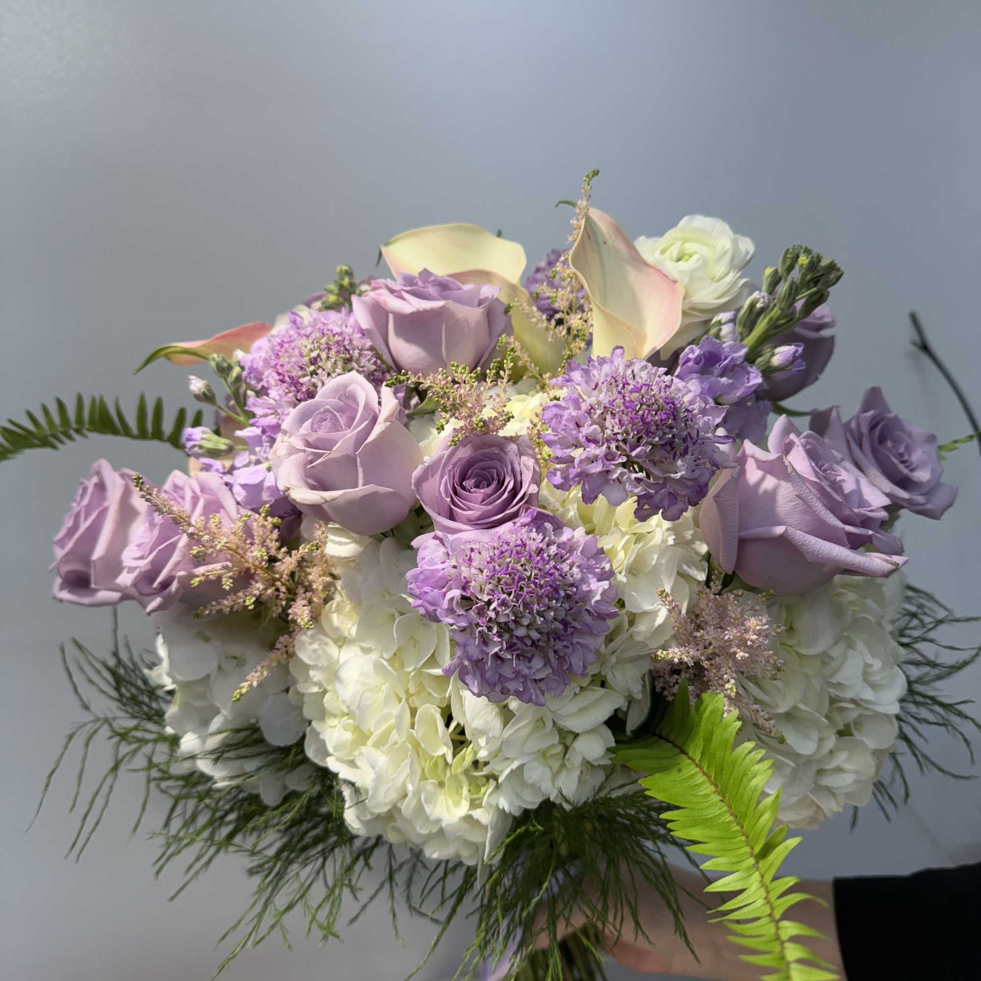 Lavender roses and white hydrangeas in a hand-tied bouquet