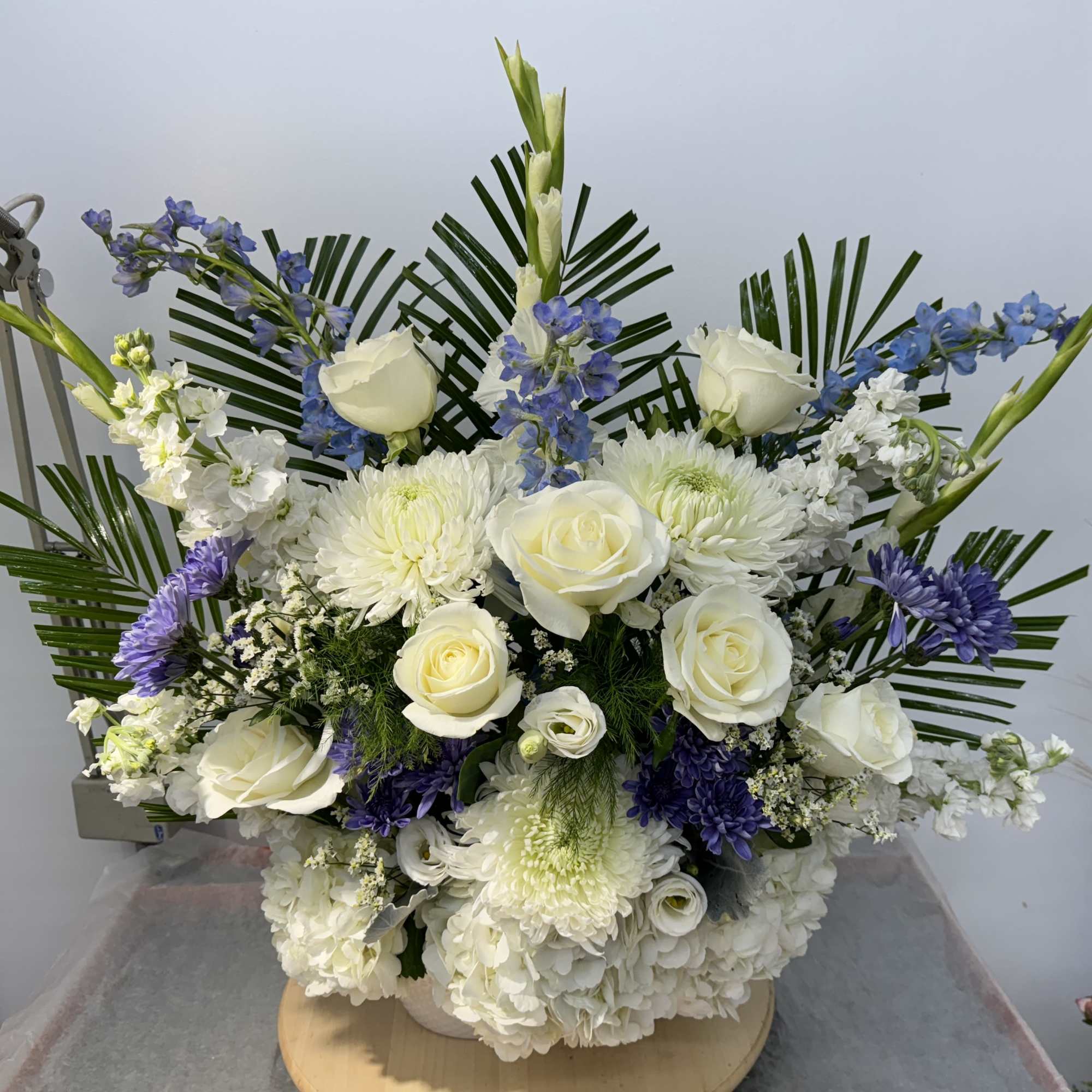 White roses and chrysanthemums with blue flowers in a low arrangement