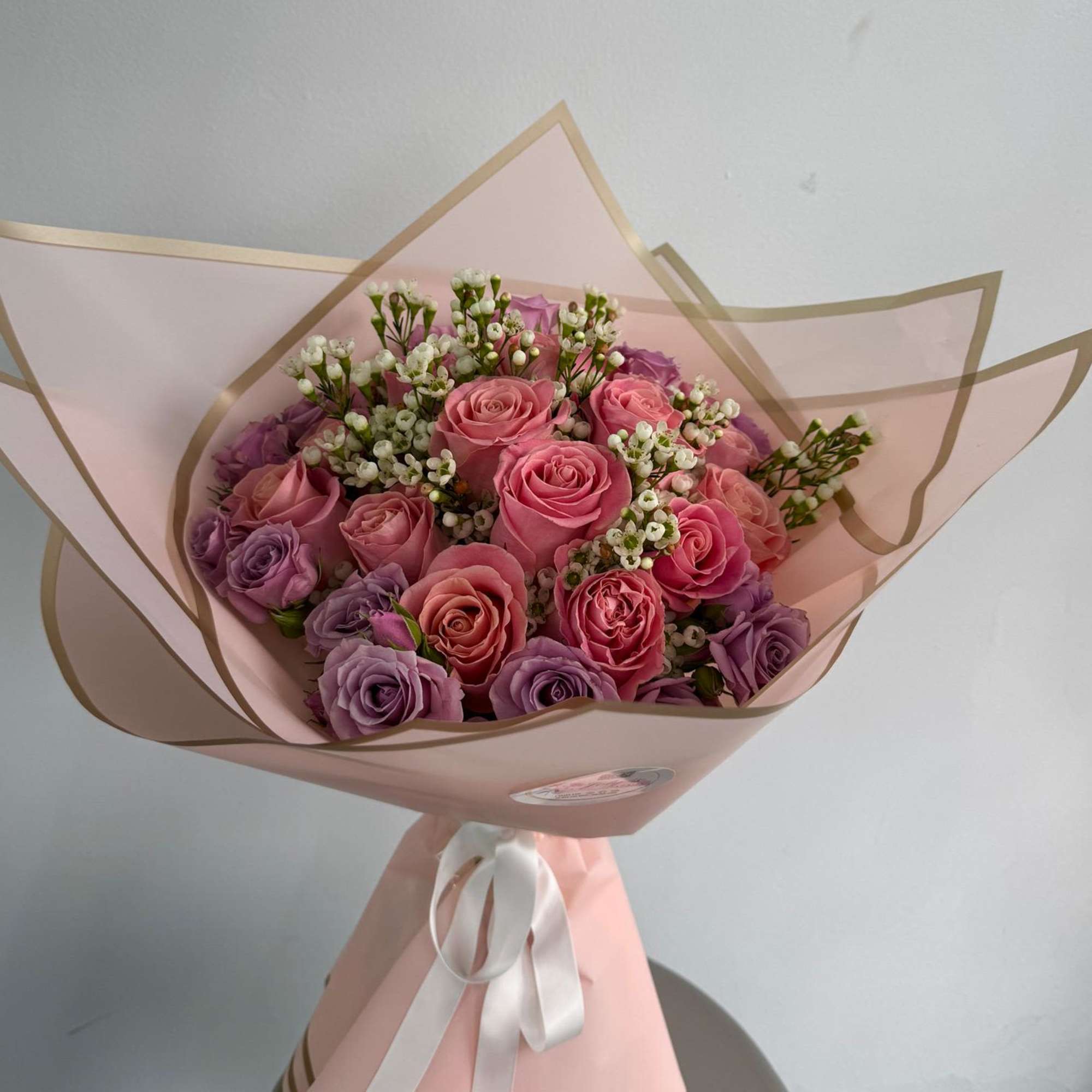 Pink and lavender rose bouquet wrapped in pale pink paper