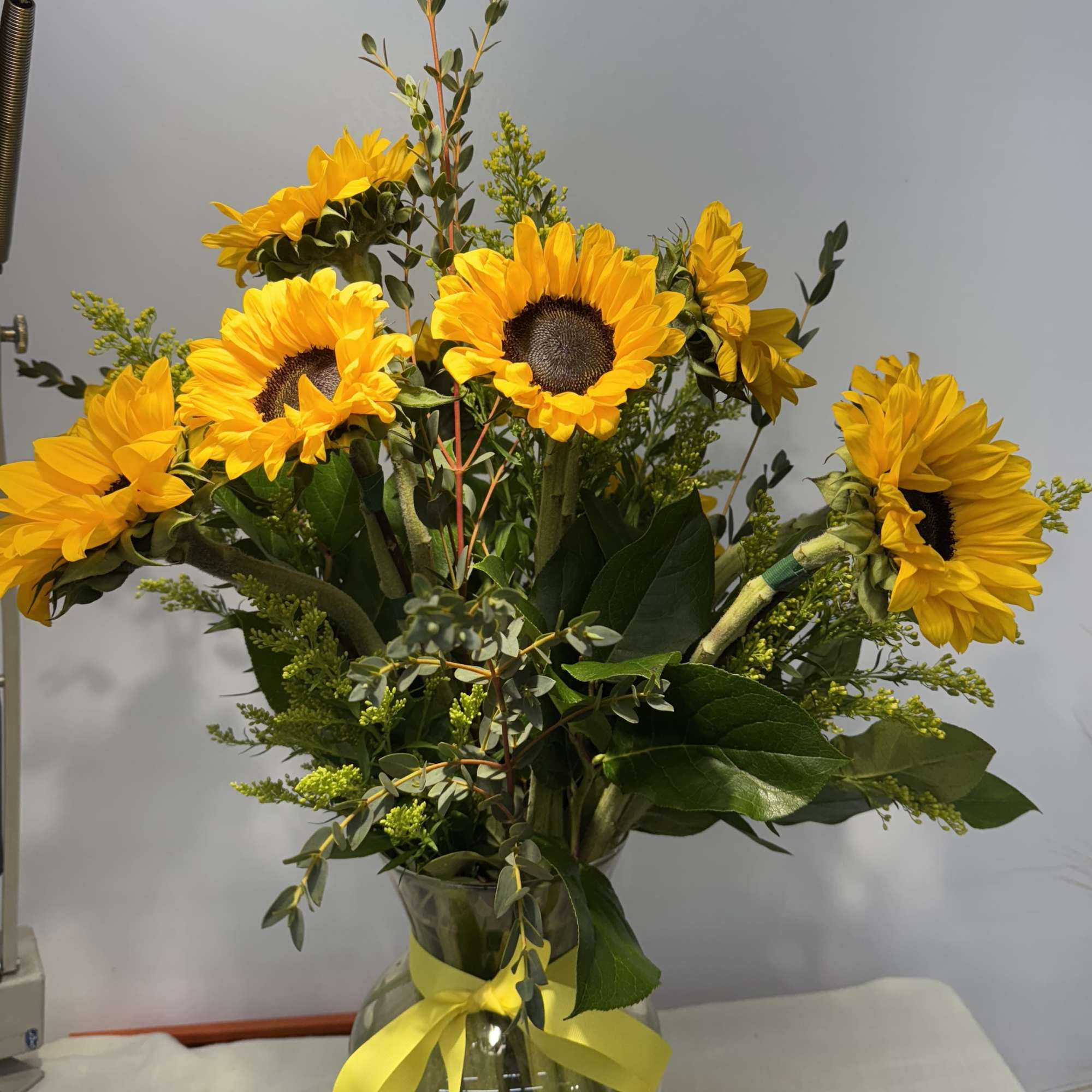 Sunflower bouquet in a glass vase with a yellow ribbon, photo 2 of 2