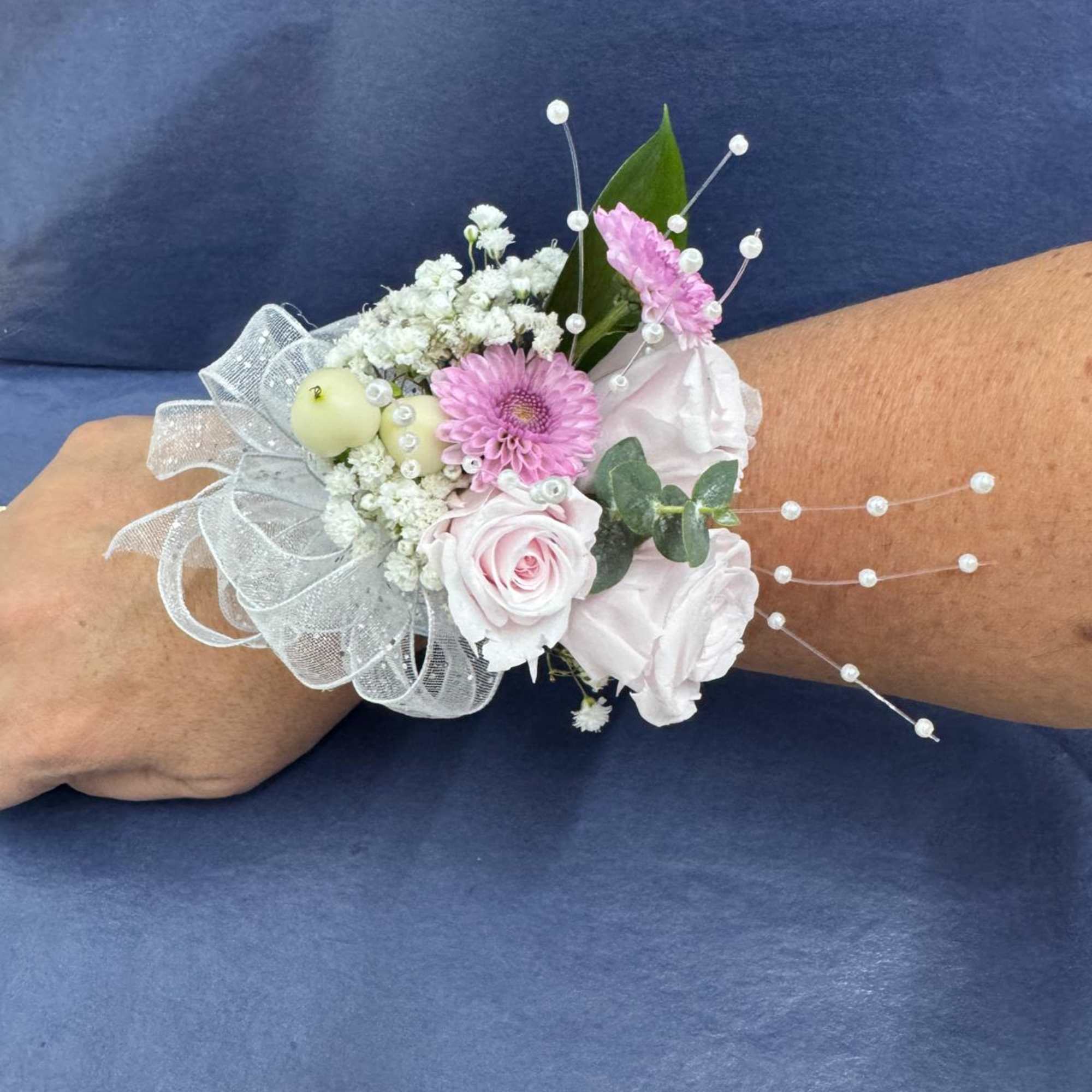 Pink and white wrist corsage with ribbon and pearl accents
