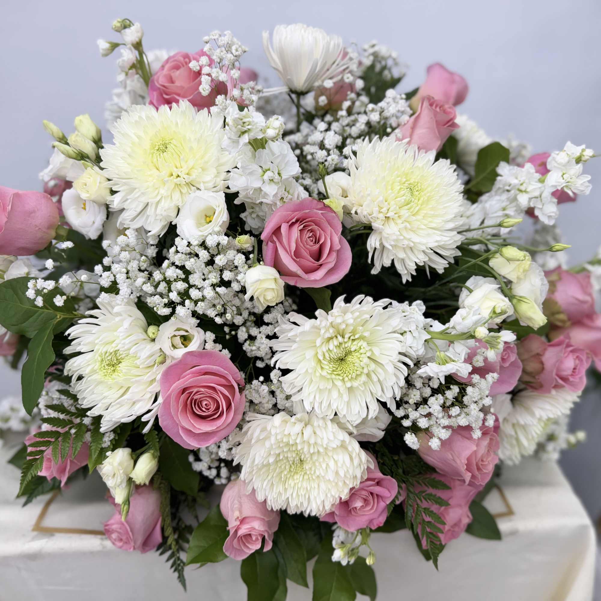 Pink roses and white chrysanthemums arranged in a low bouquet