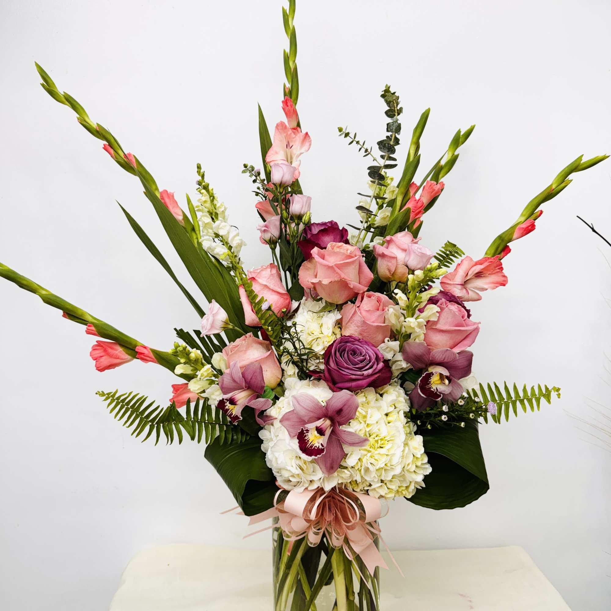 Tall bouquet of pink and white flowers in a clear glass vase