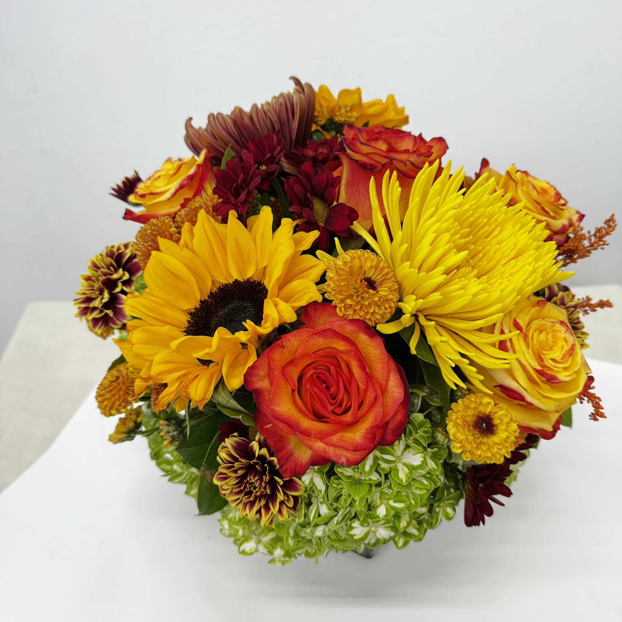 Bouquet of yellow sunflowers, red roses, and chrysanthemums