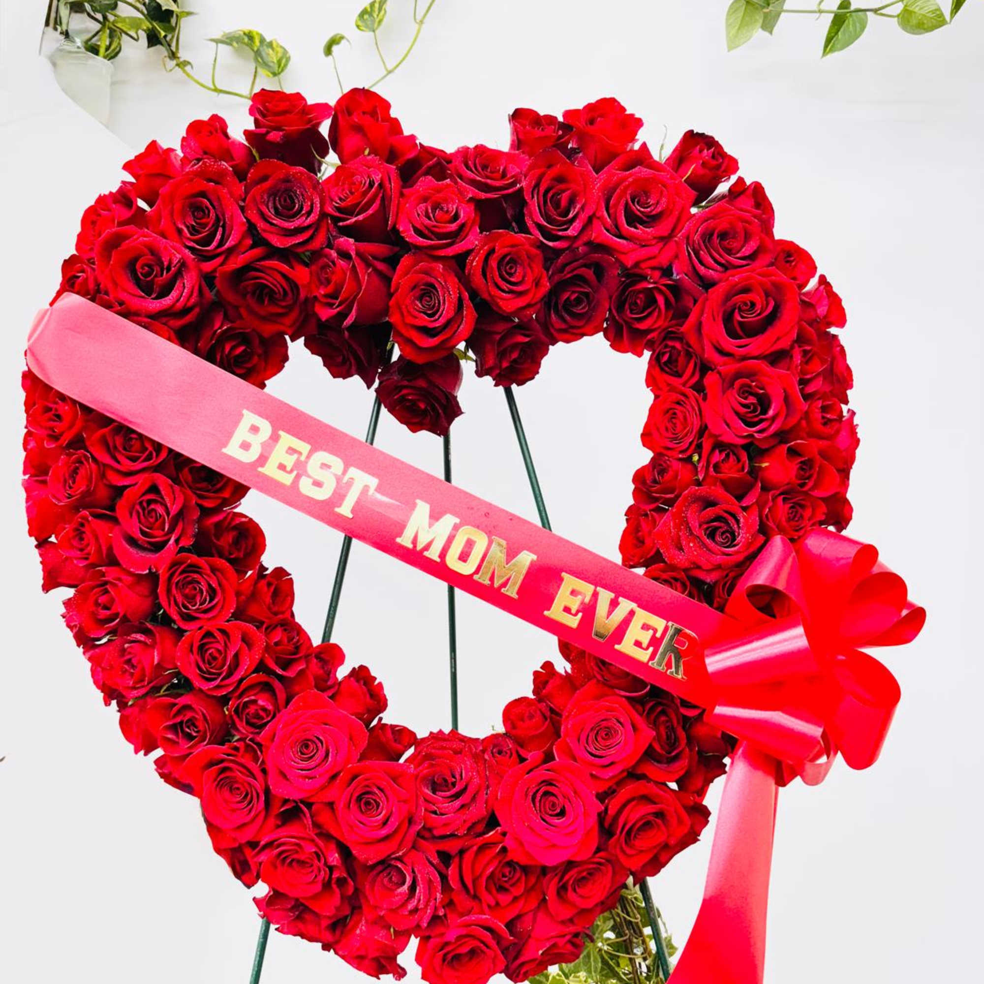 Heart-shaped red rose wreath with a pink "BEST MOM EVER" ribbon