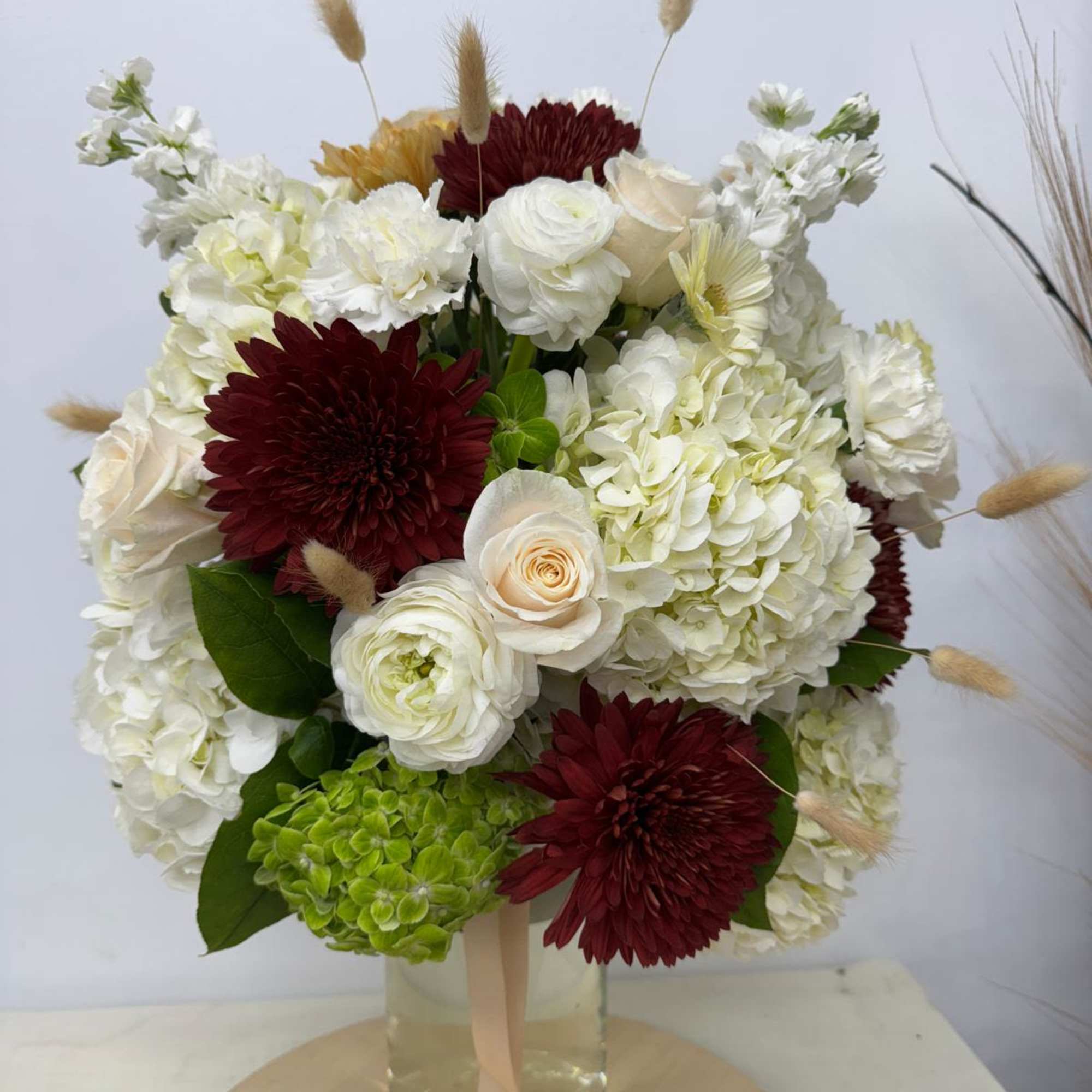 Bouquet of white and burgundy flowers in a glass vase, photo 2 of 2