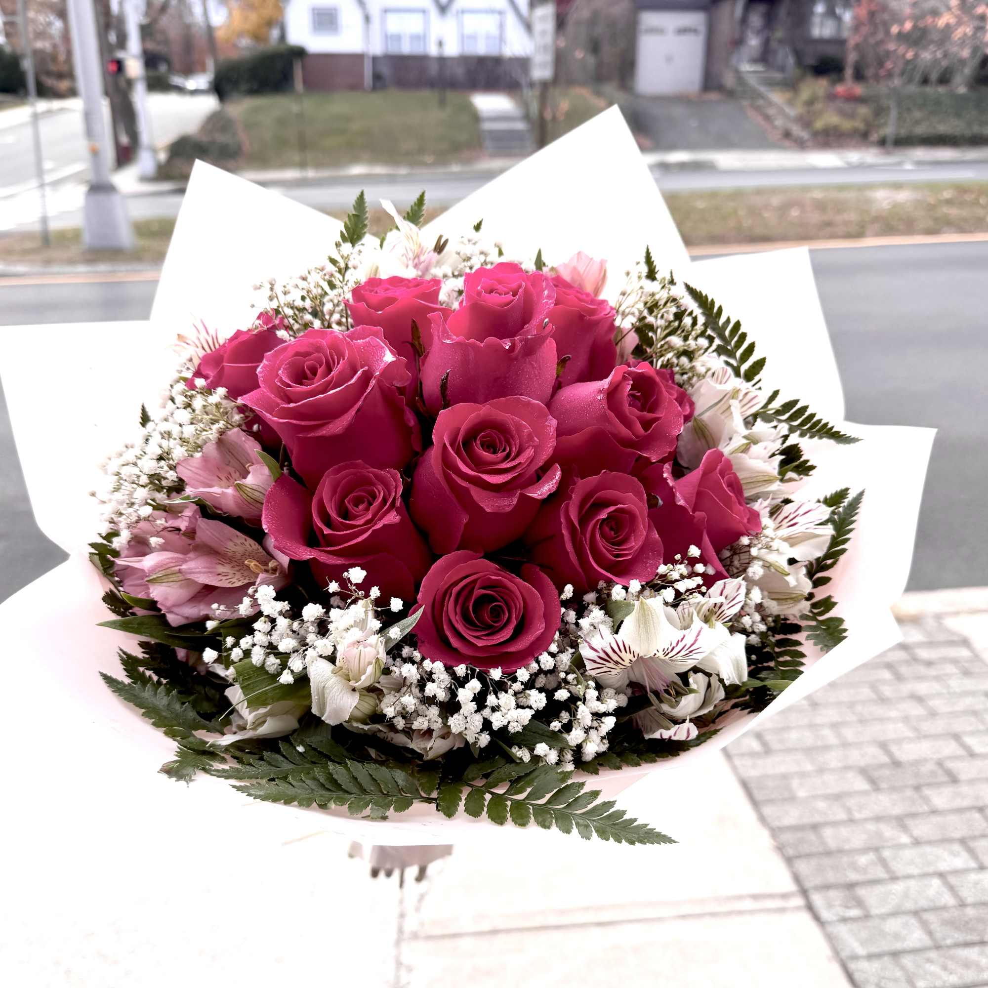 Bouquet of hot pink roses with white filler flowers and pale pink accents