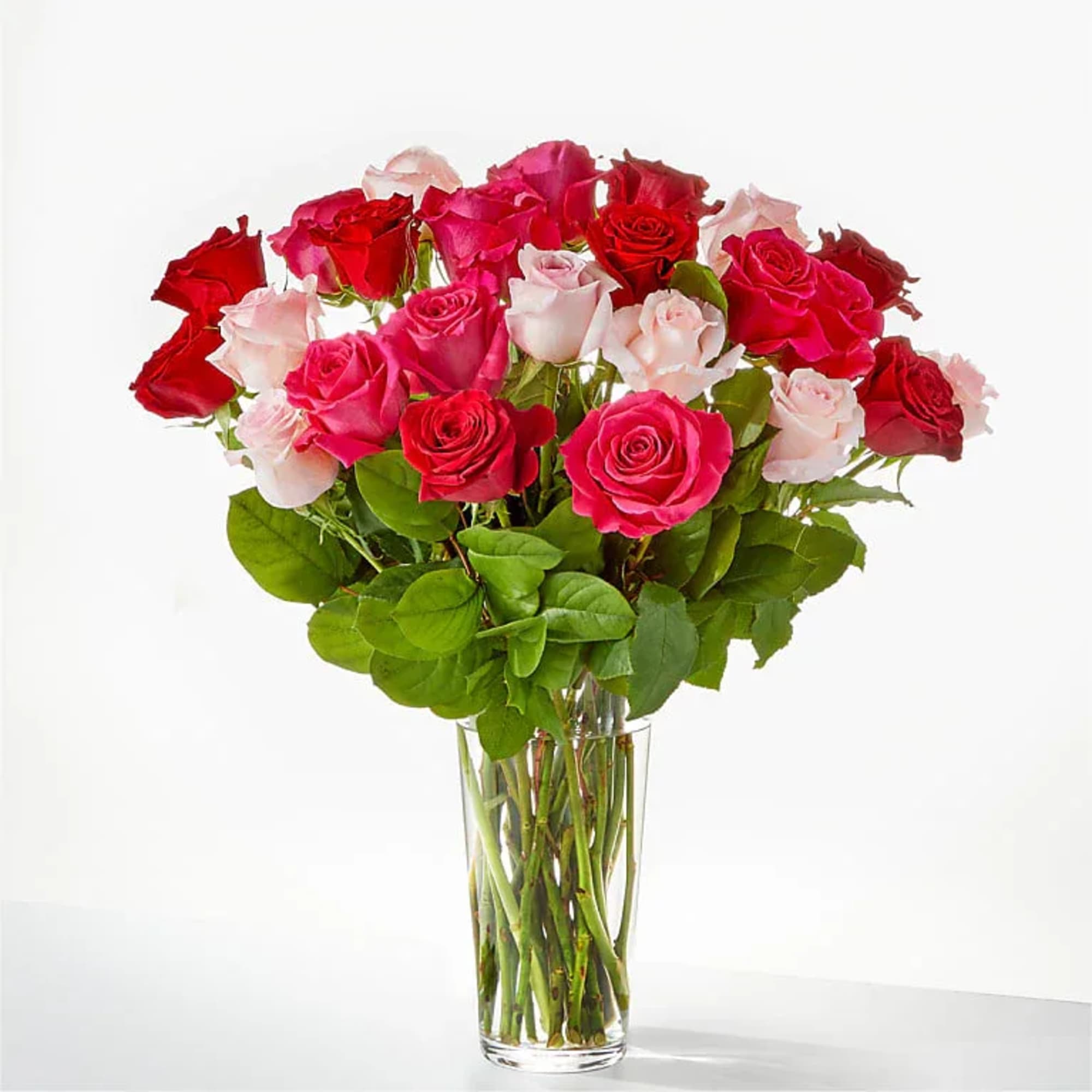 Bouquet of red, pink, and pale pink roses in a clear glass vase