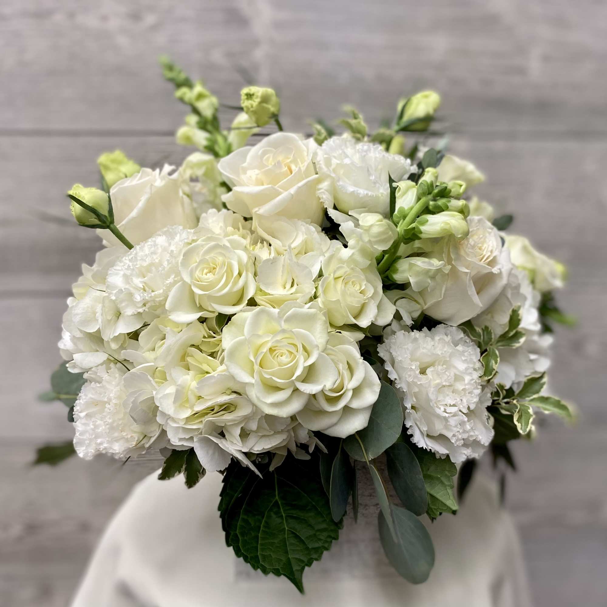 White rose and hydrangea bouquet with green accents