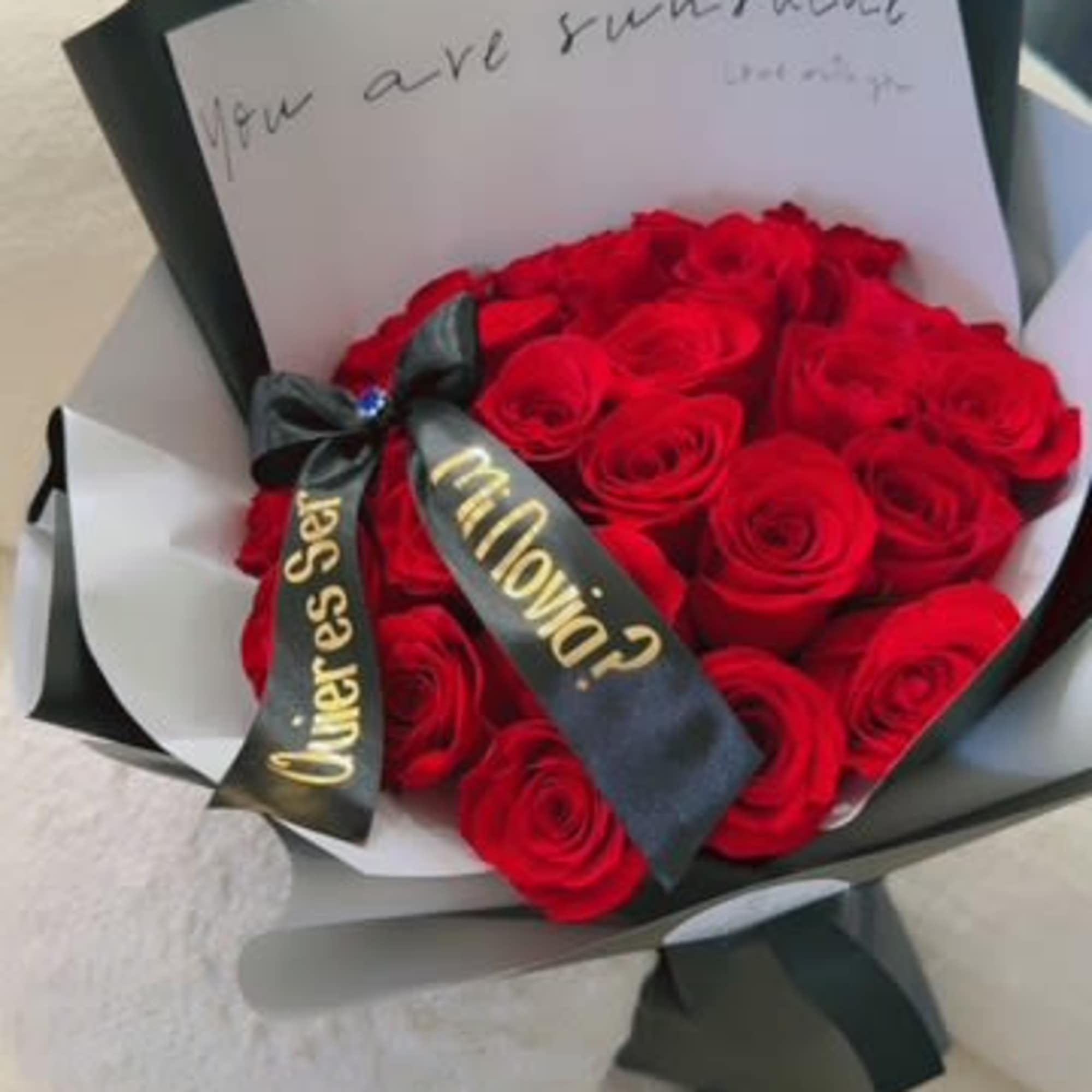 Bouquet of red roses wrapped in black and white paper with a ribbon