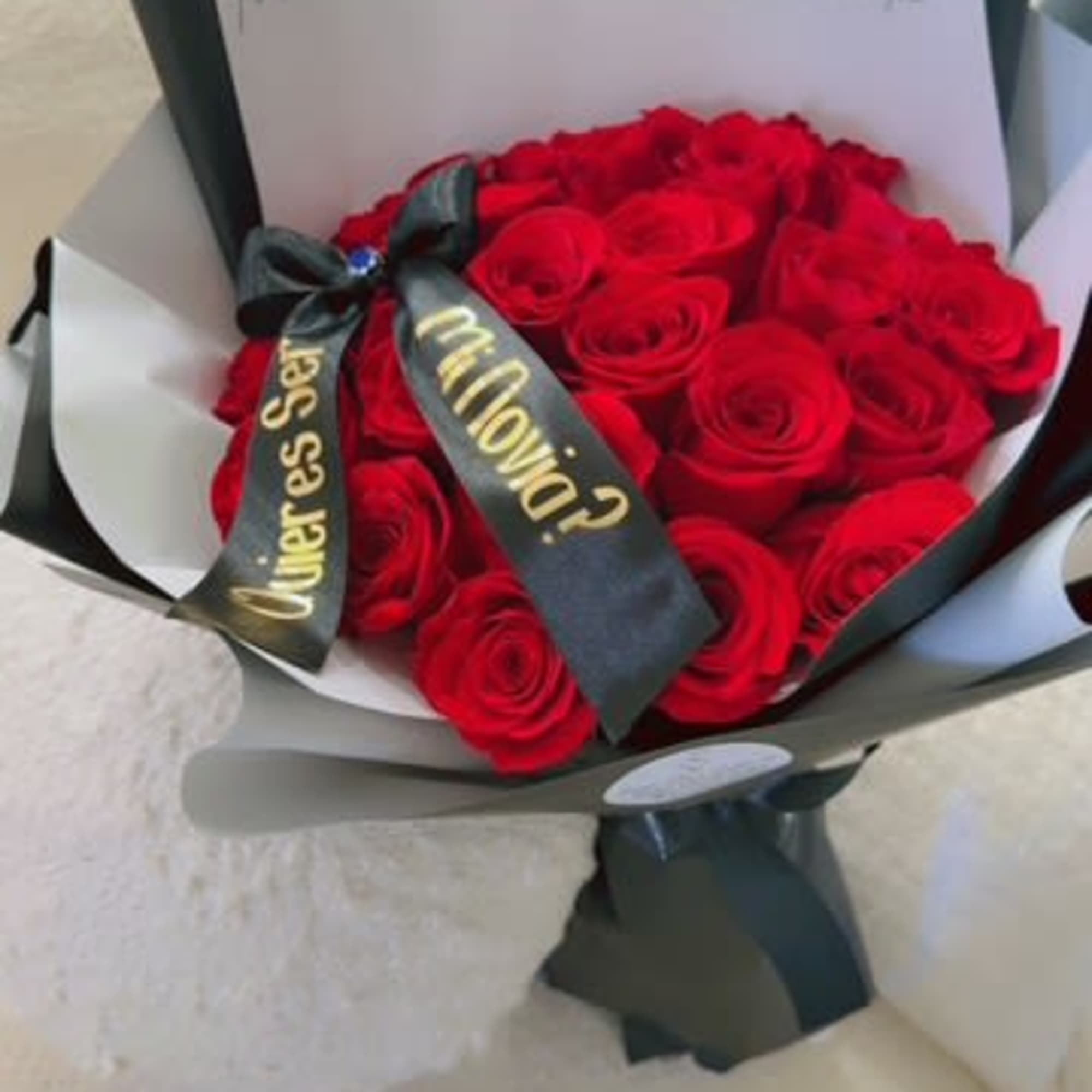 Bouquet of red roses wrapped in black and white paper with a ribbon
