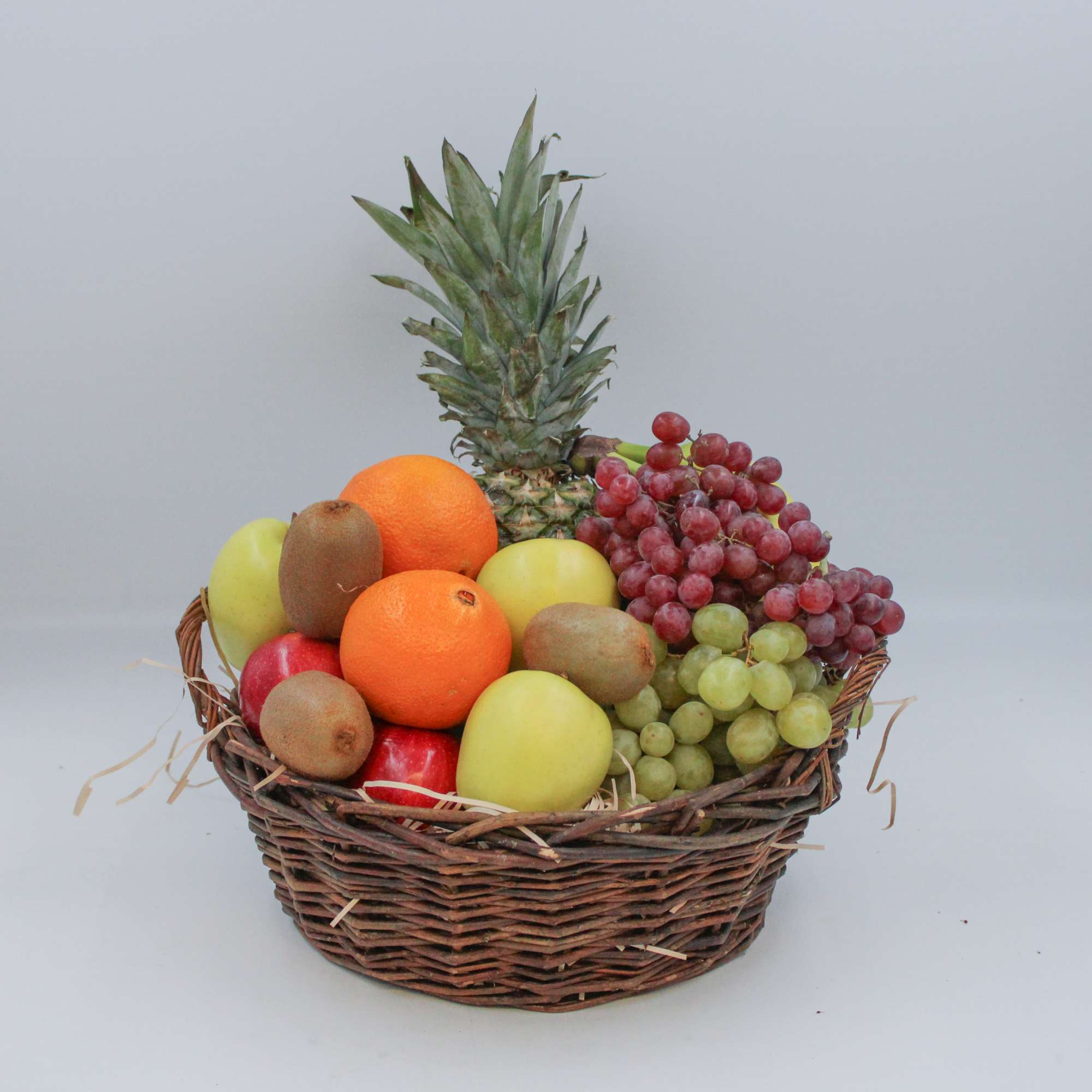 A delightful basket of fresh fruits including Oranges, Apples, Bananas, Pears, Kiwis