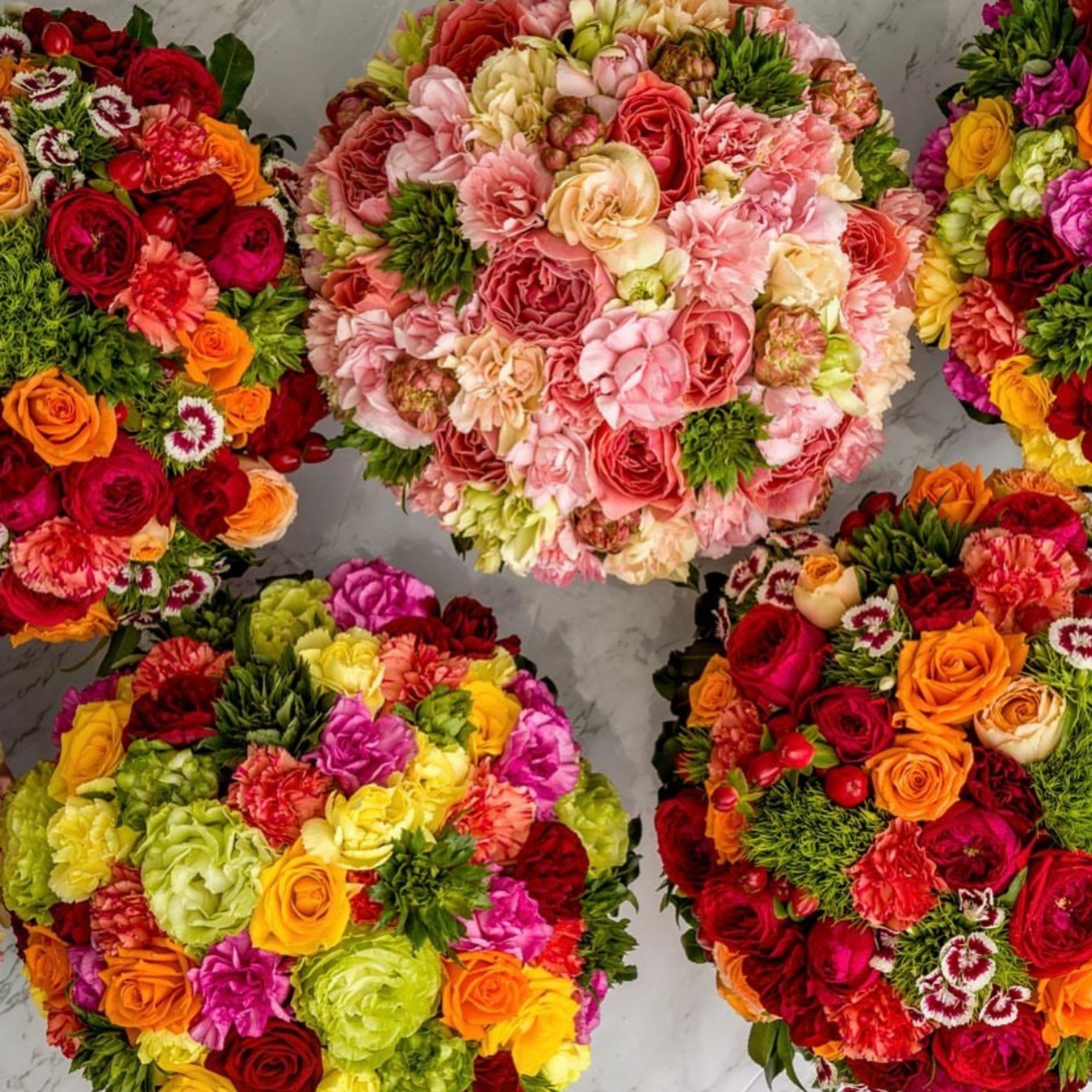 Four round bouquets of mixed roses and carnations in bright colors