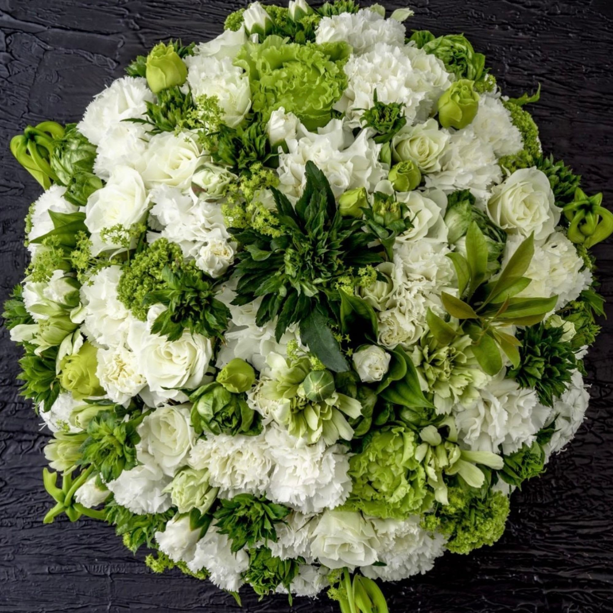 Round bouquet of white and green flowers on a dark background