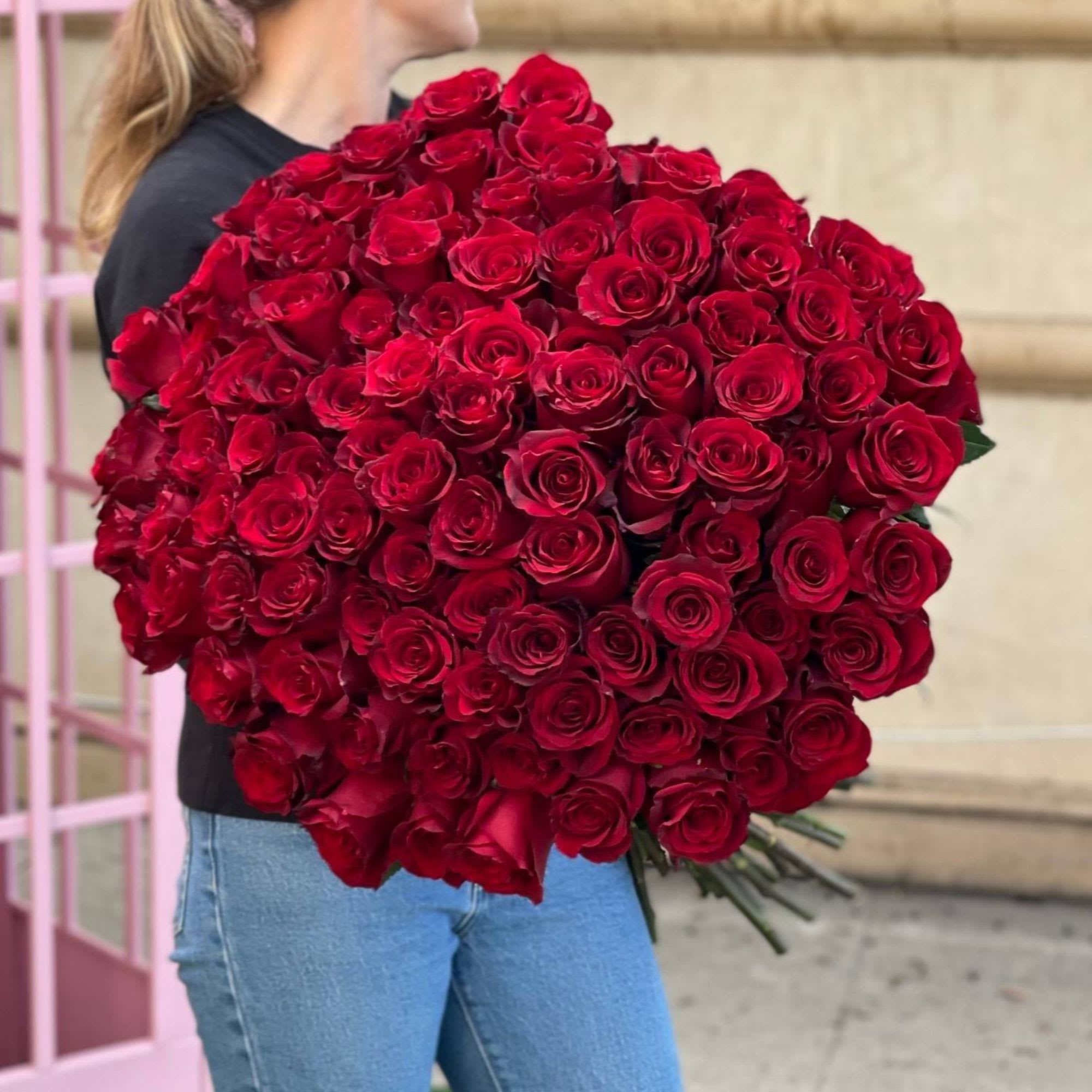 Large bouquet of red roses held by a person