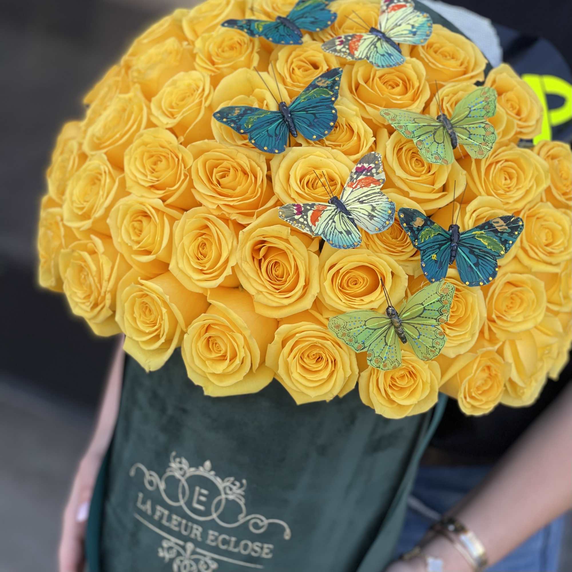 Yellow rose bouquet with decorative butterflies in a green wrap