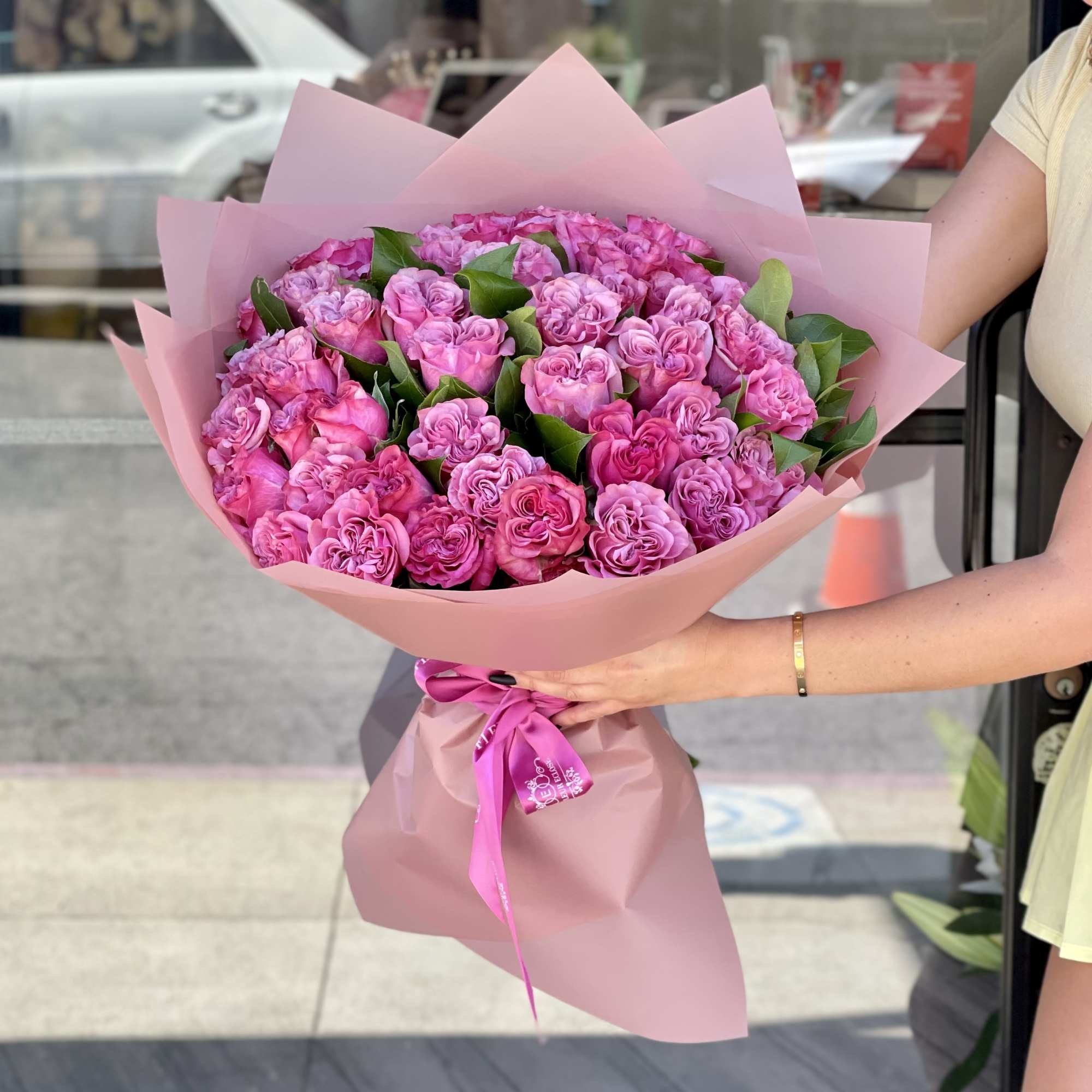 Large bouquet of pink roses wrapped in pink paper