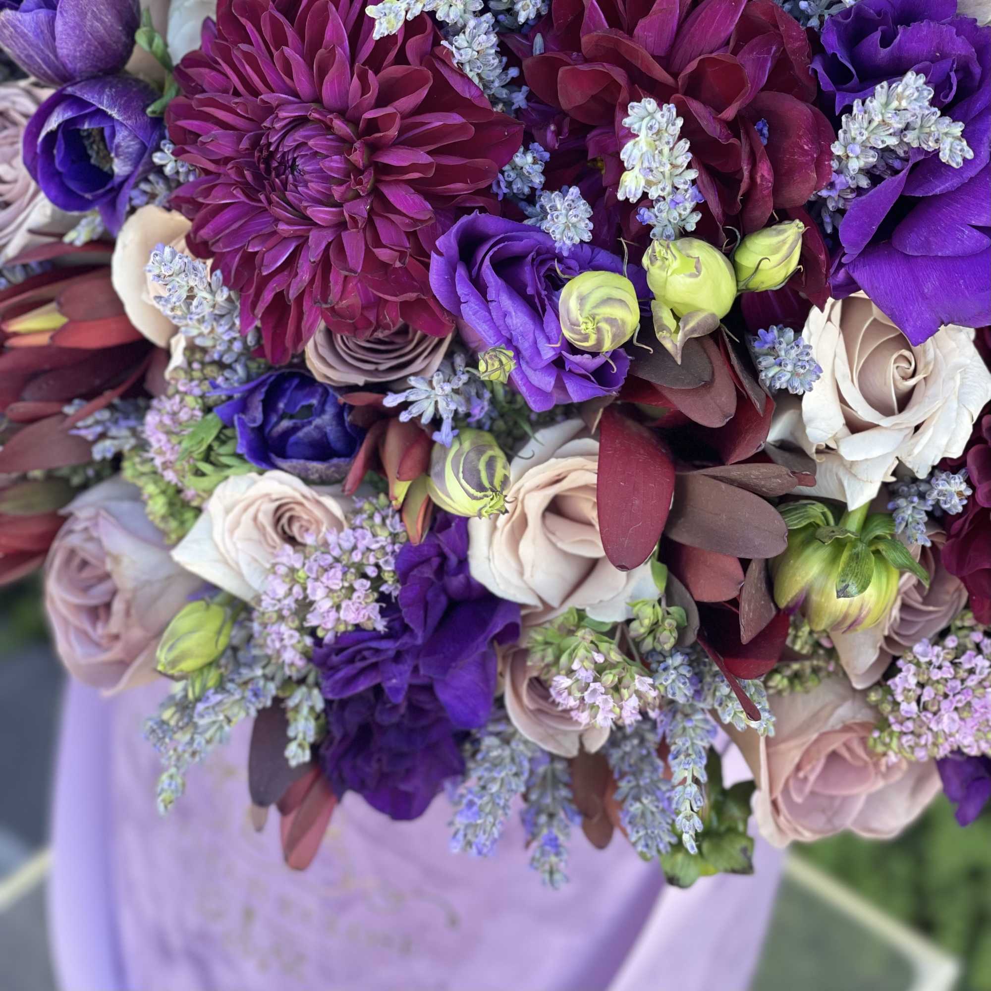 Bouquet of purple, burgundy, and blush flowers with small lavender filler blooms