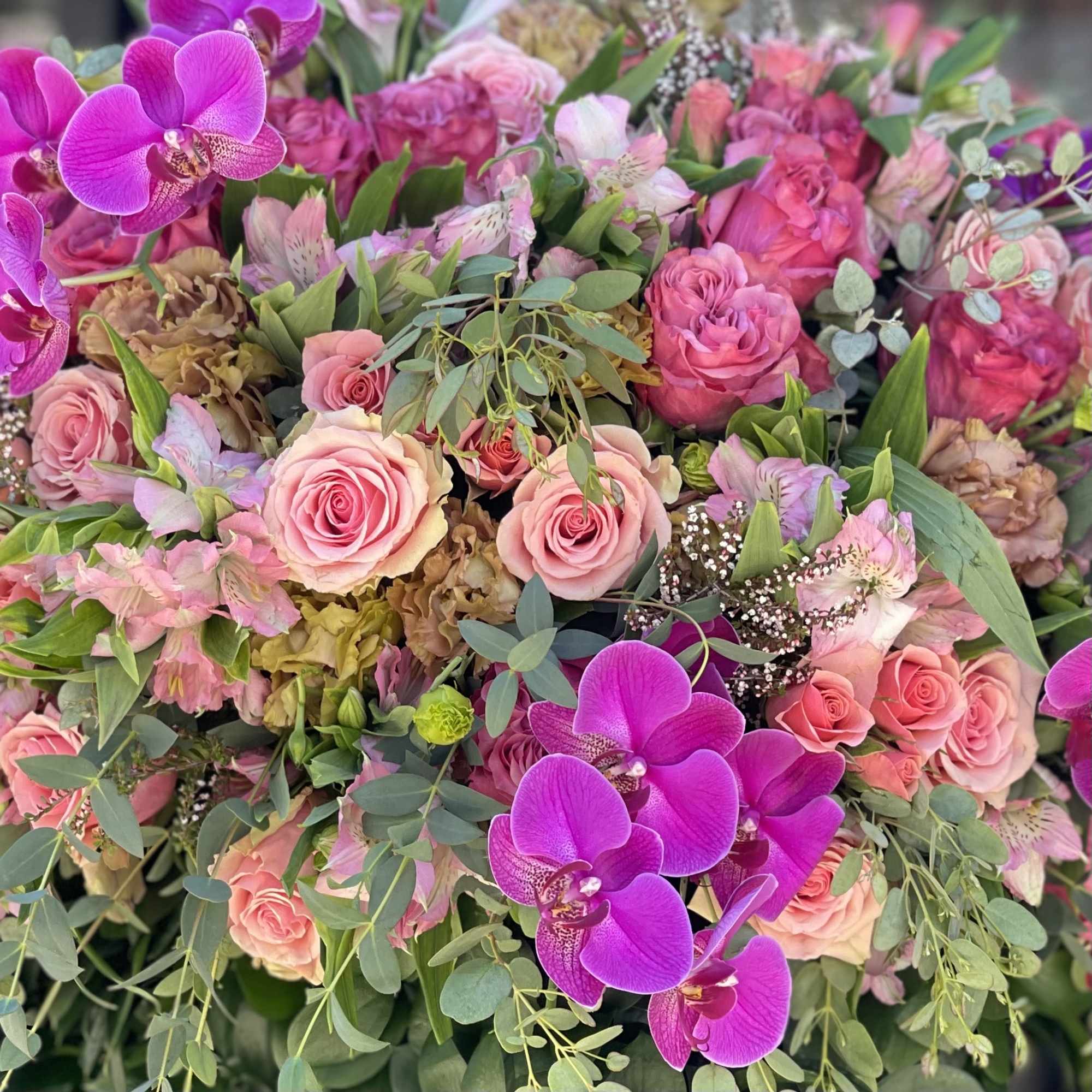 Pink roses and purple orchids in a lush mixed bouquet