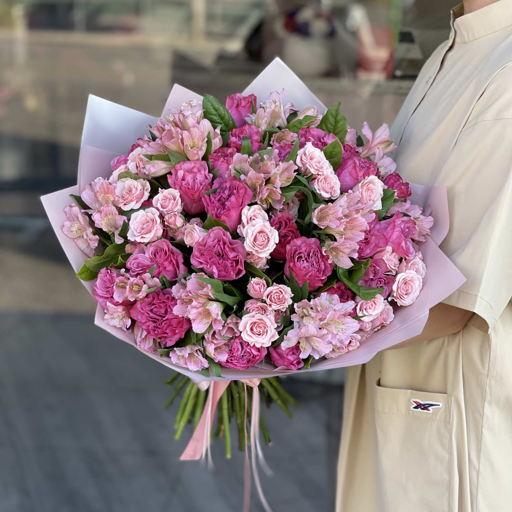 Large pink bouquet of roses and alstroemeria wrapped in pastel paper