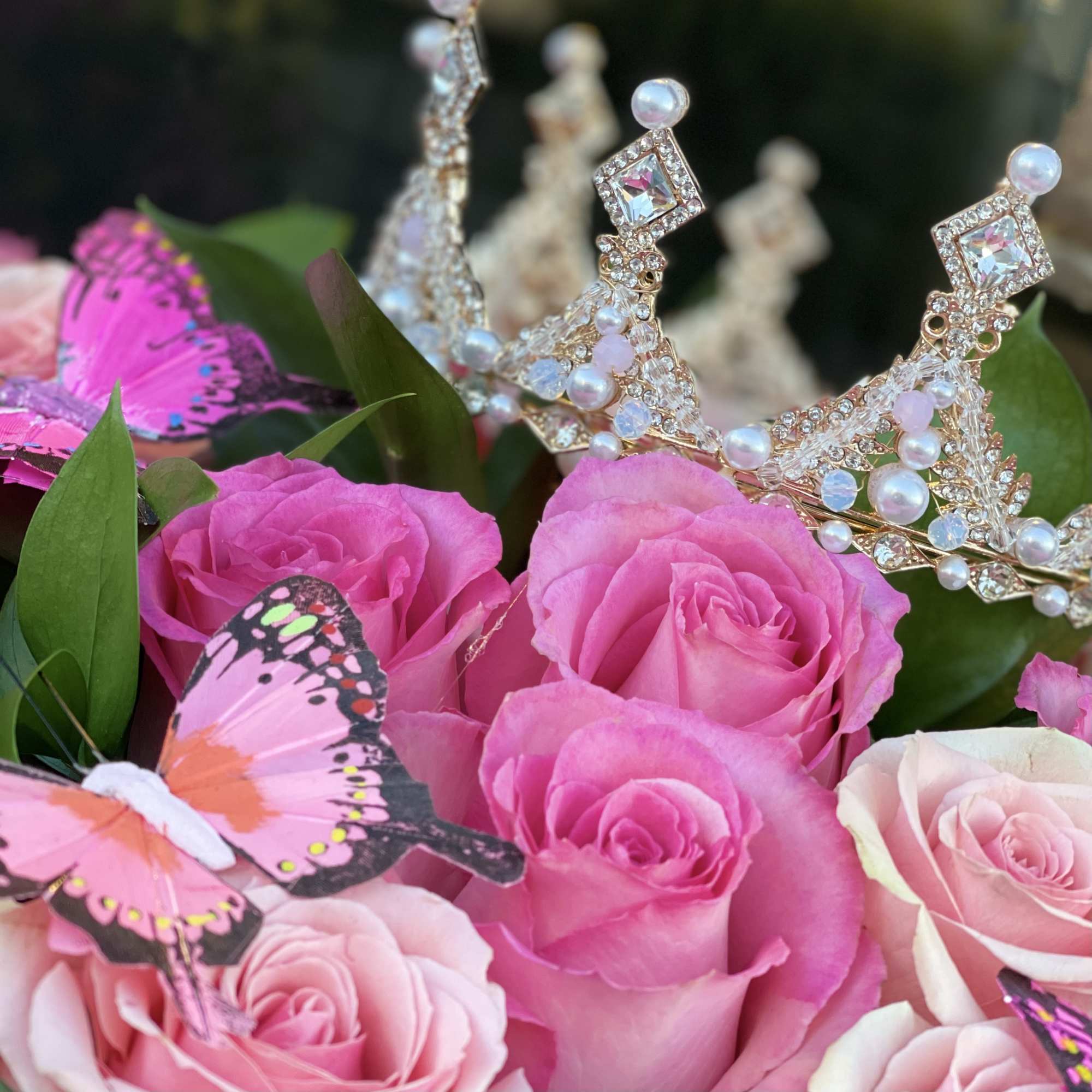 Pink roses with jeweled crowns and butterfly decorations